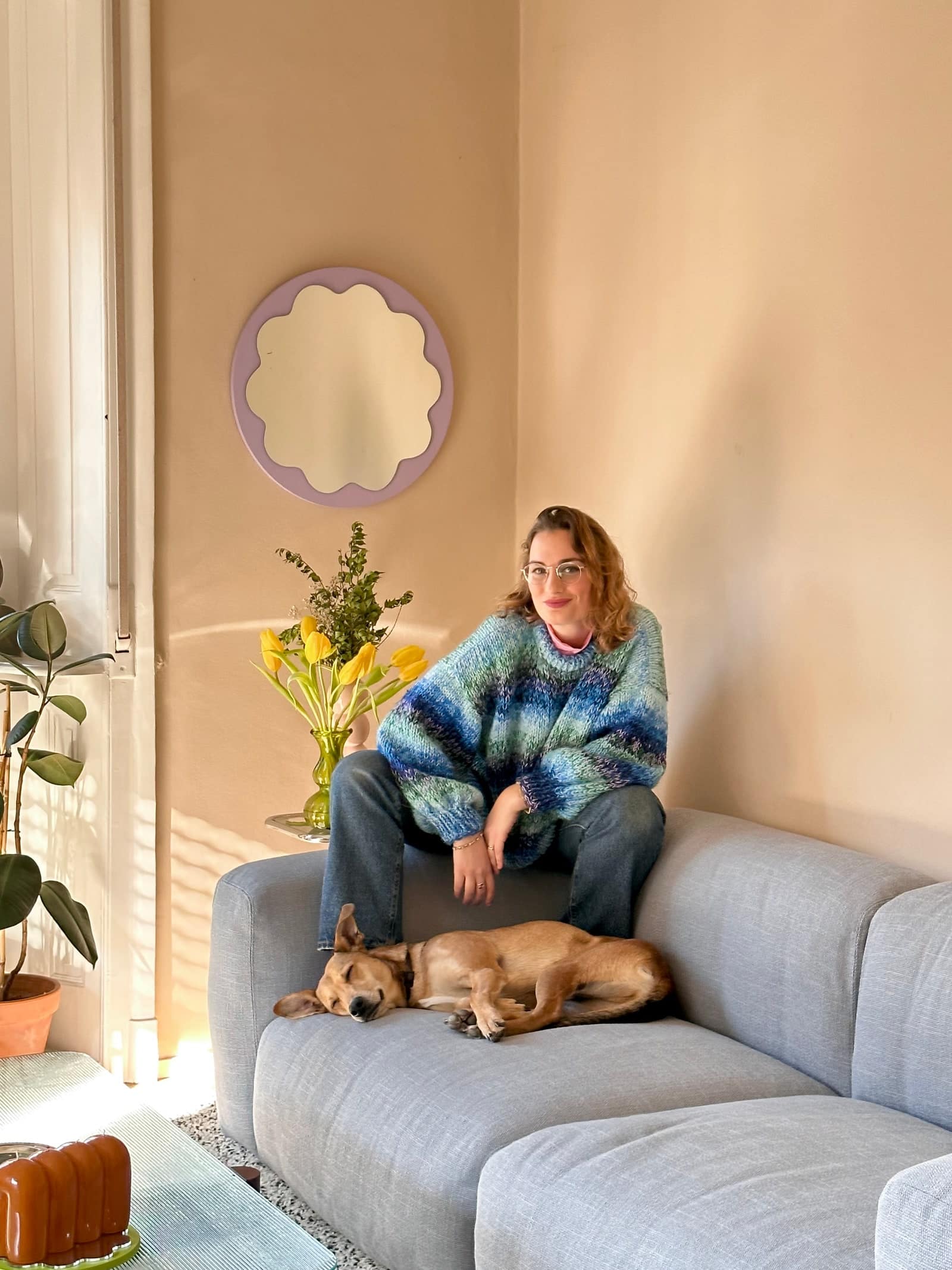 Jazmín Feige and her pup relax on their custom sofa in Milan.