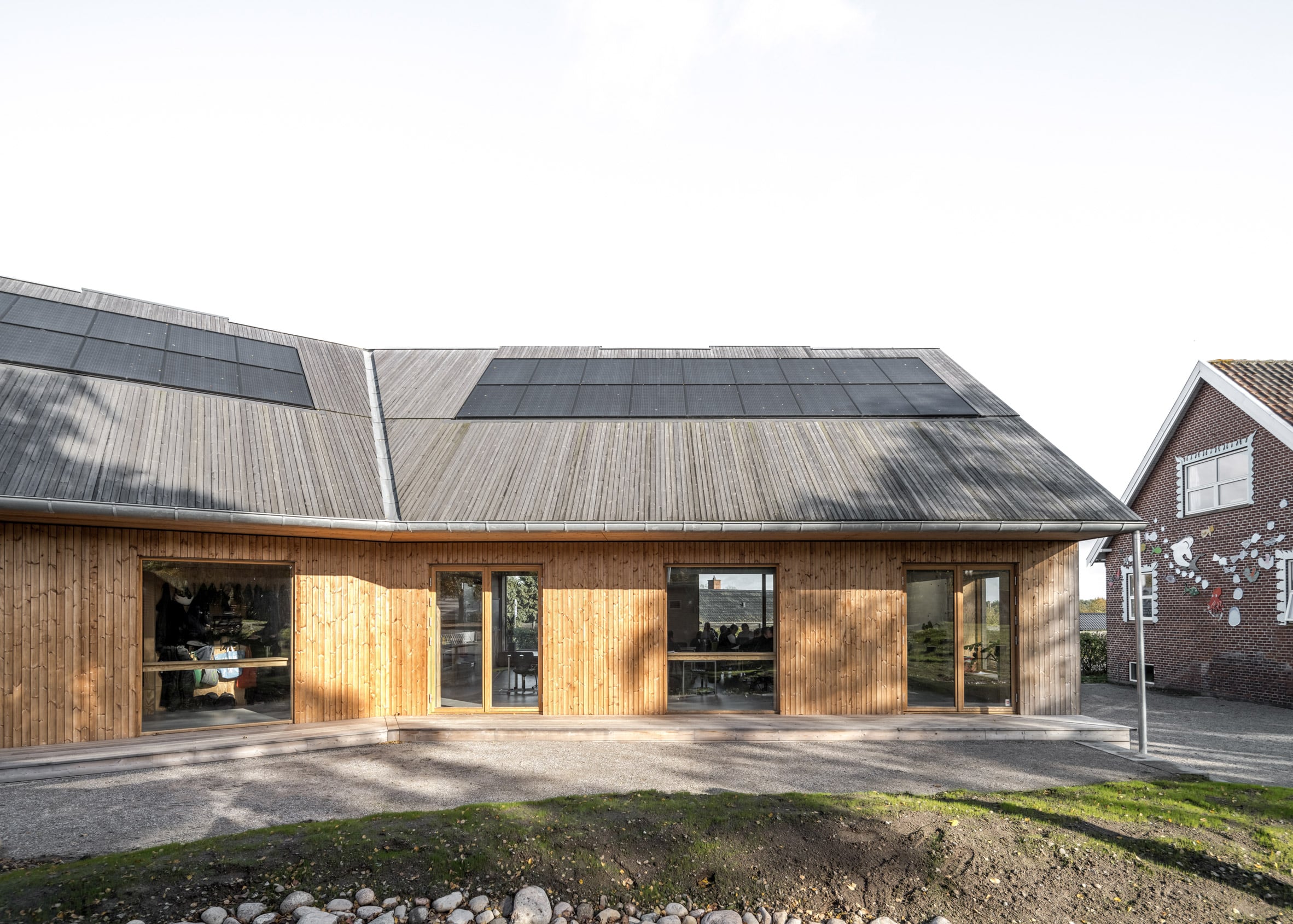 Wood-lined building with solar panels on the roof
