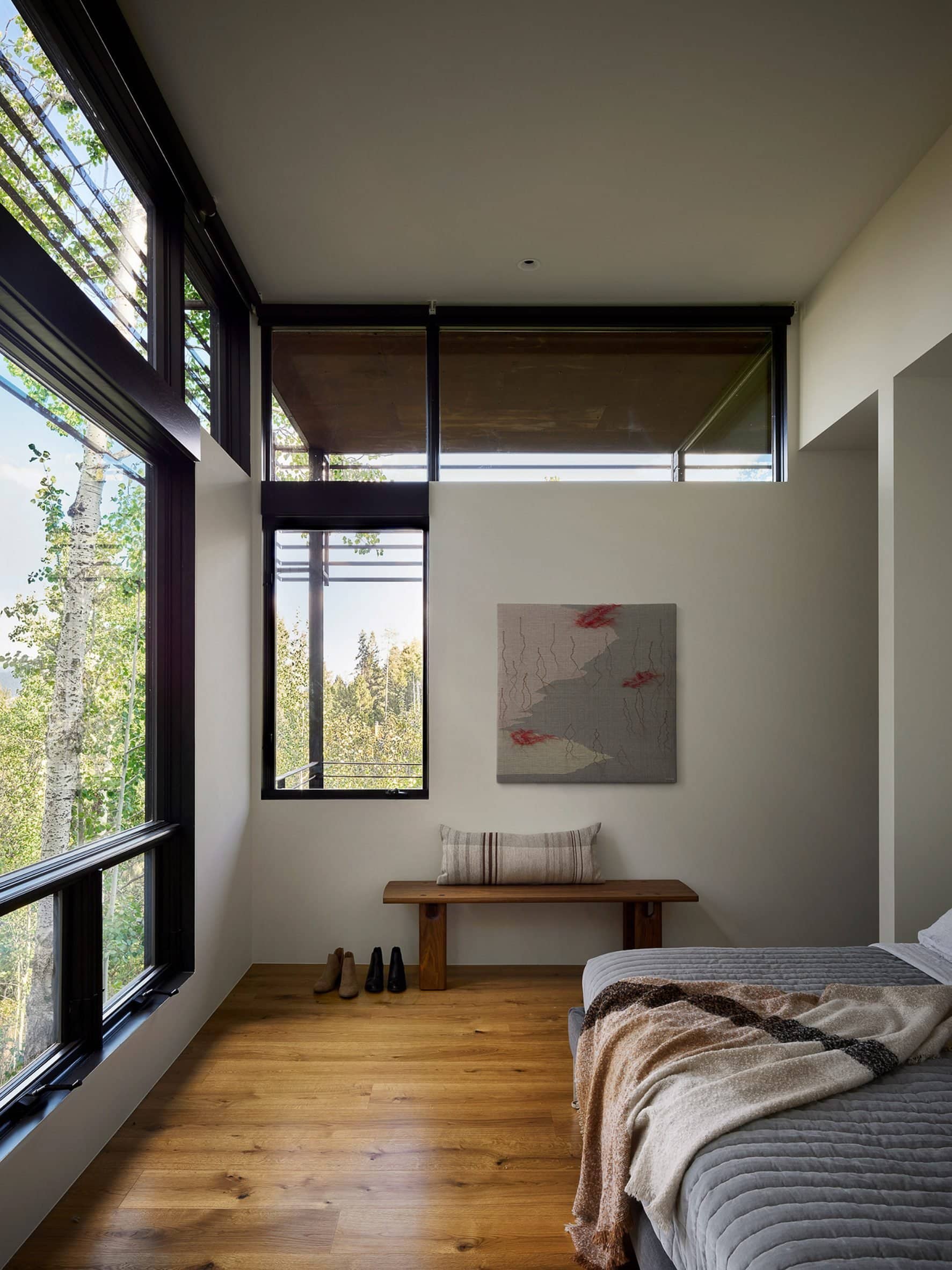 Wooden floors and white walls within bedroom of house by CLB Architects