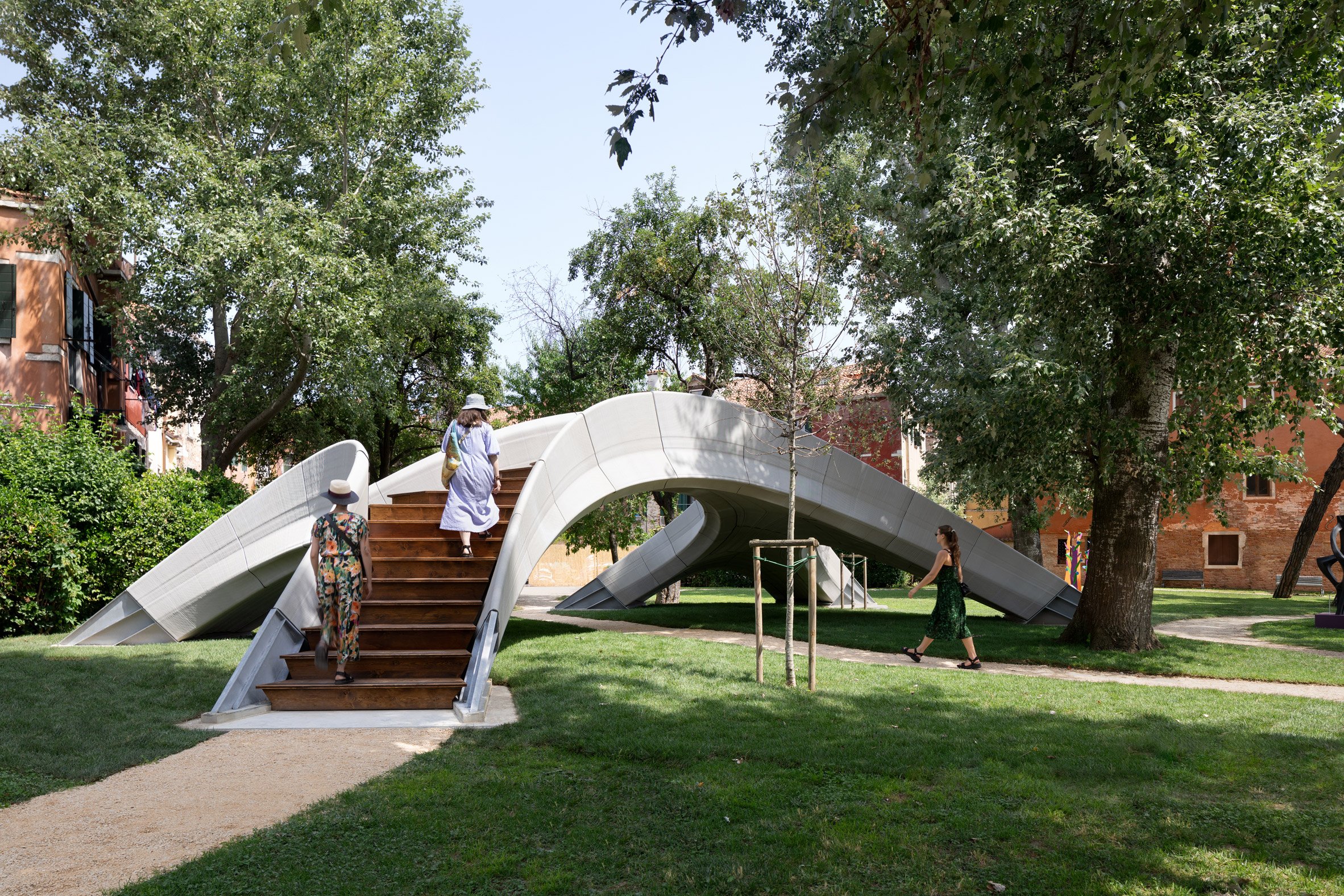 Two women climbing up the stairs of Striatus 3D-printed concrete footbridge