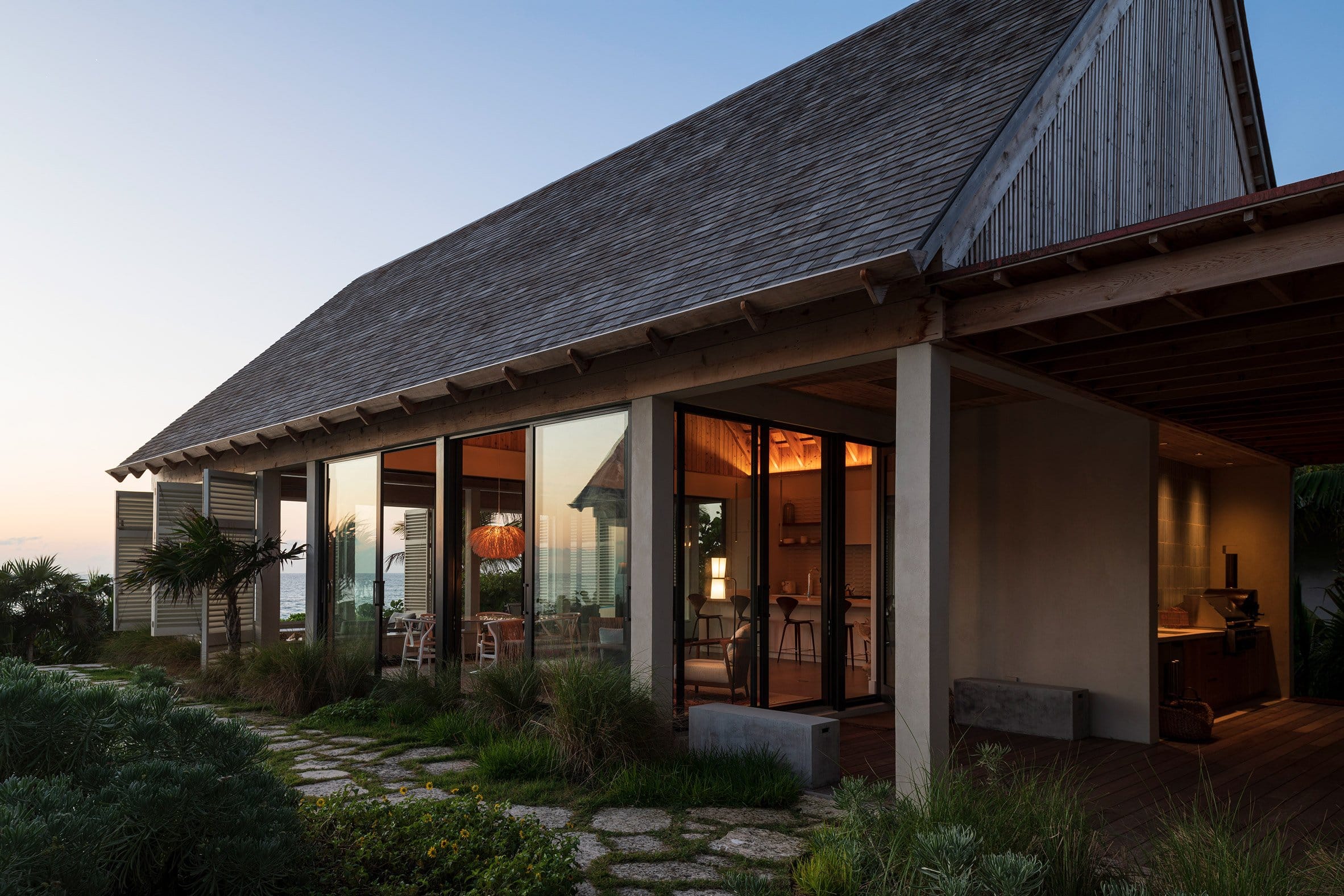Gabled roof and sliding floor-to-ceiling glazing and shutters on Bahamas house by Brillhart and Garth Sawyer