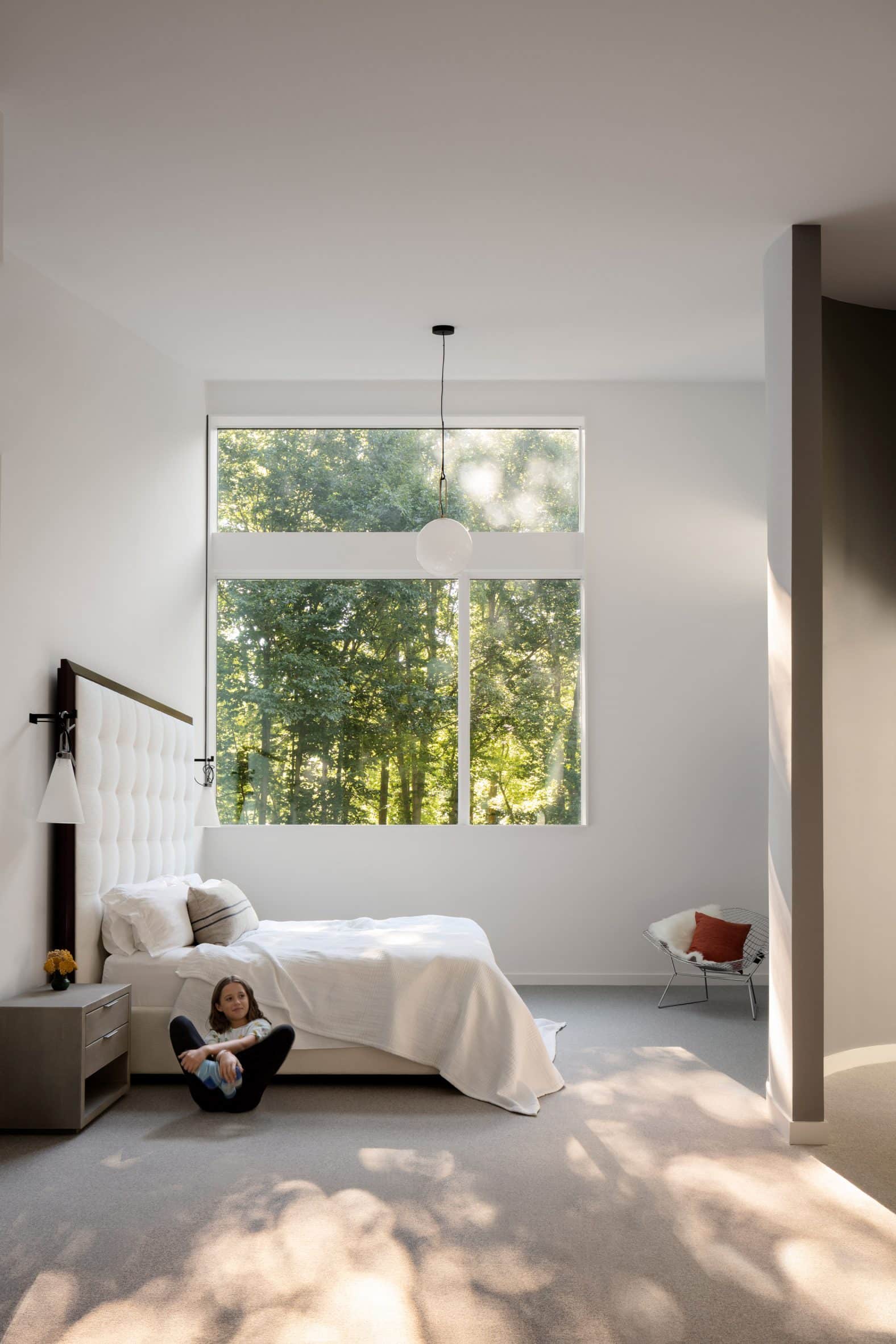 Girl in white bedroom with modern bulb lamp