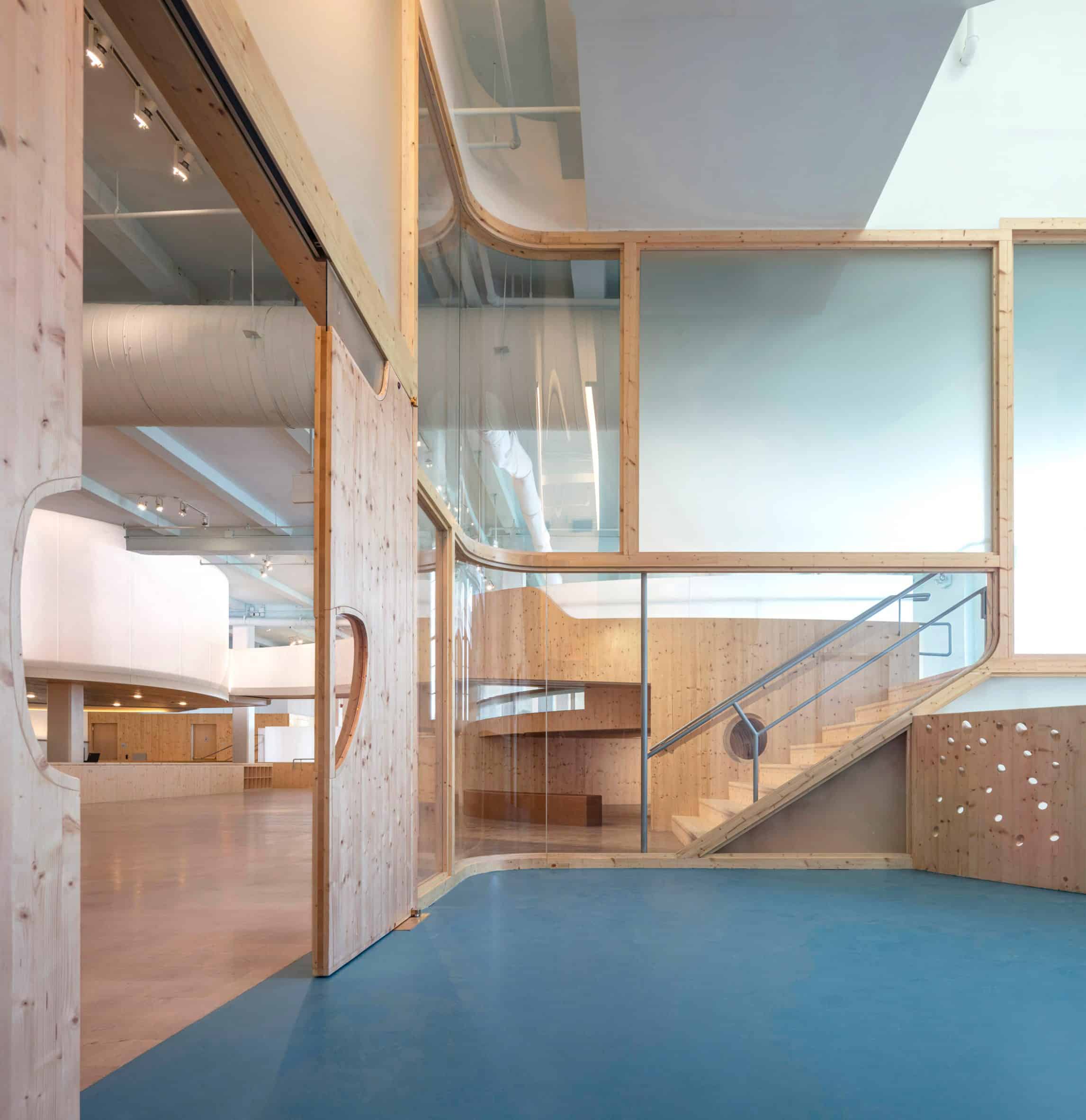 Playroom in a museum with green carpet, square glass windows and a wood sliding door