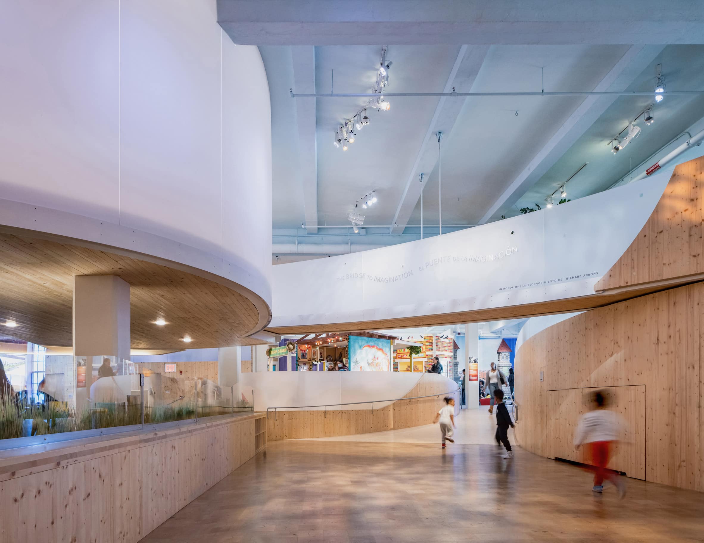 Museum interior with wood floors and overhead curving walkways