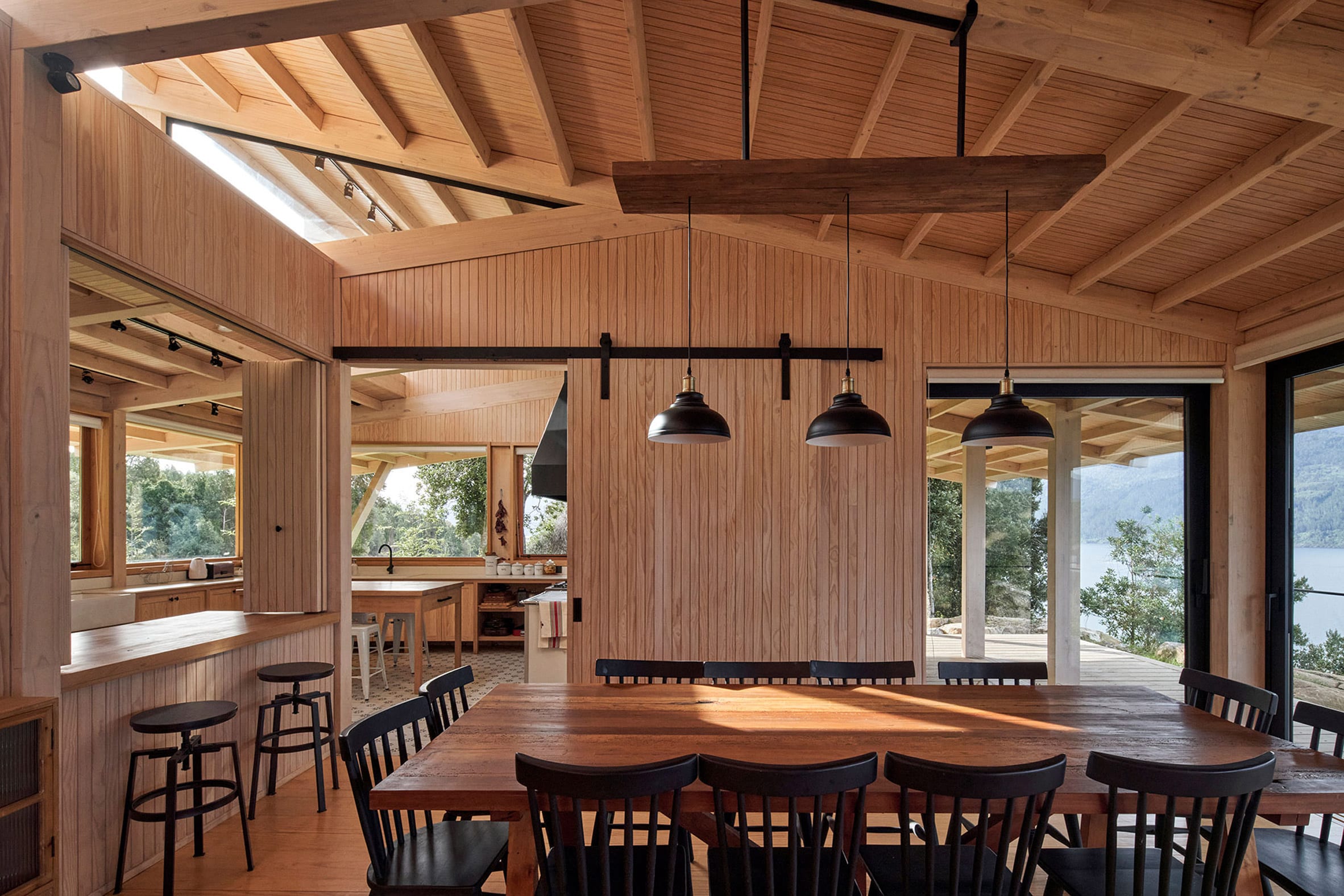 Dining room with timber-clad walls and pitched roof with exposed wood structure