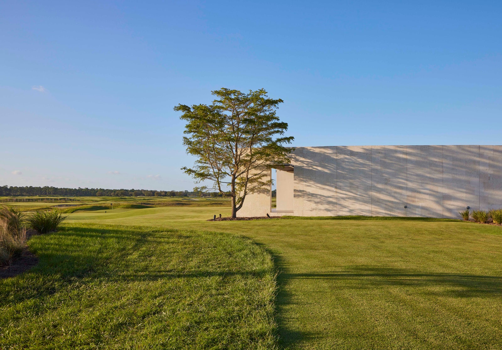 a green field with a concrete building