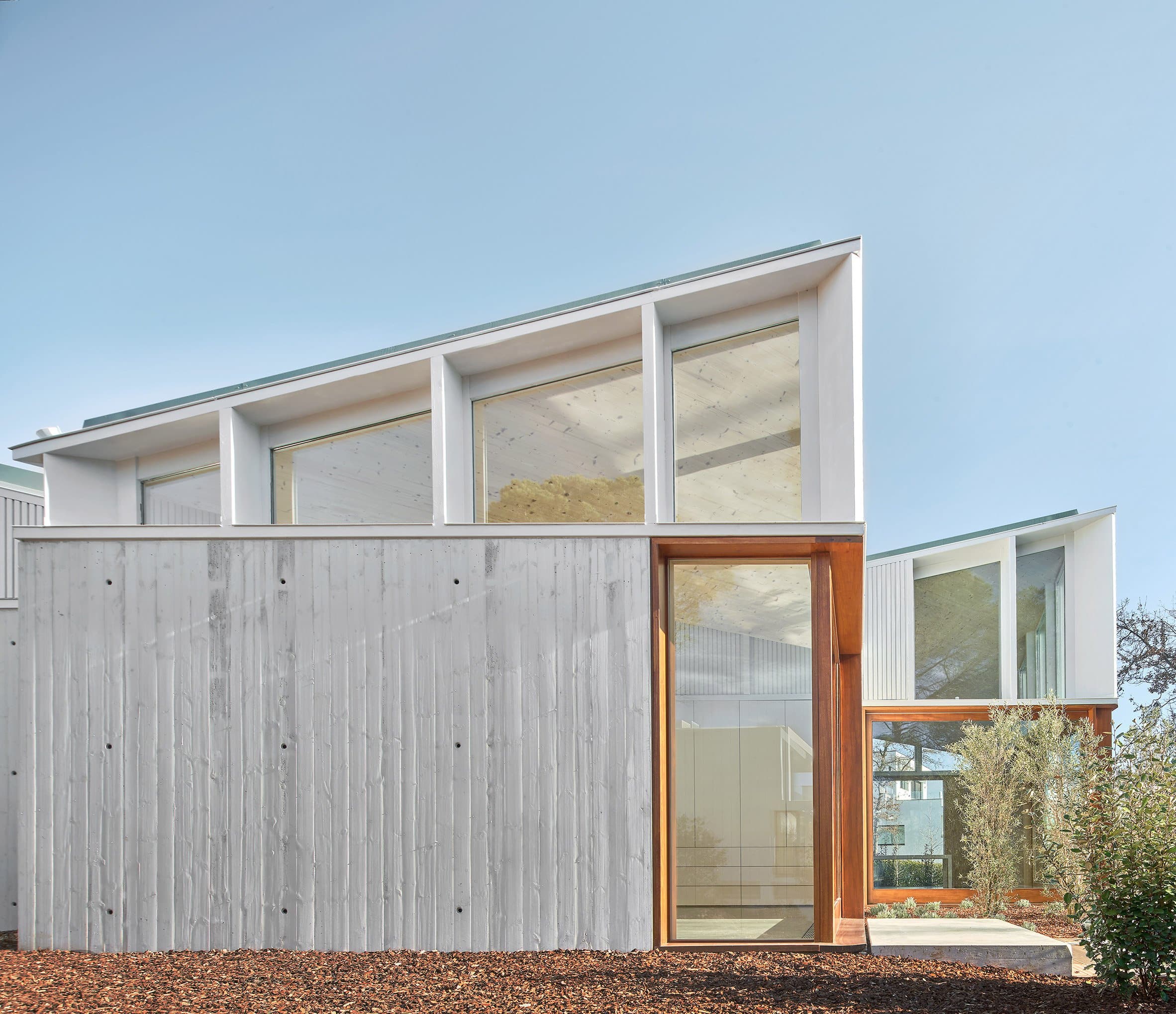 A cluster of mono-pitched square structures comprising House 016 by Arquitecturia