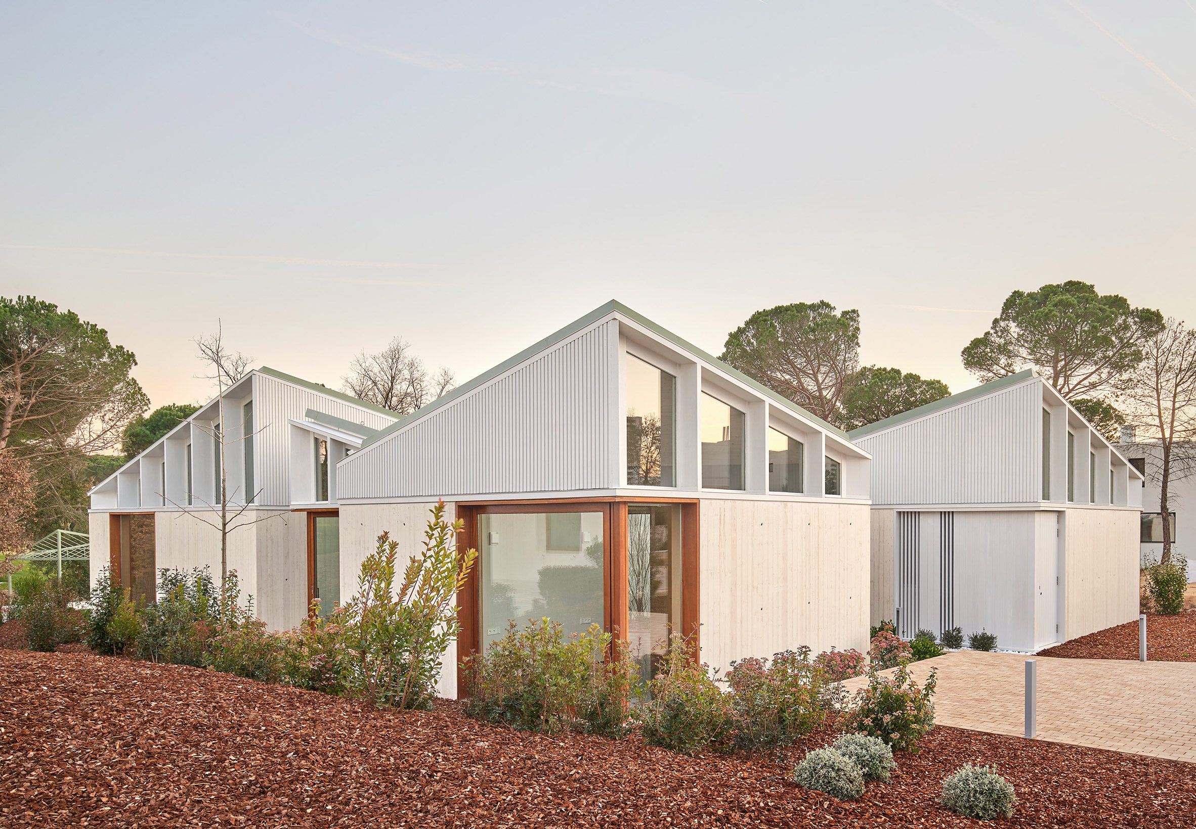 A cluster of mono-pitched square structures comprising House 016 by Arquitecturia