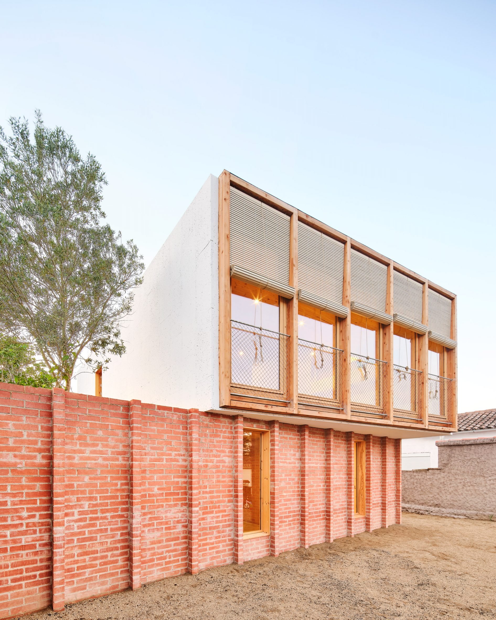 Exterior of House on a Brick Base by Agora Arquitectura