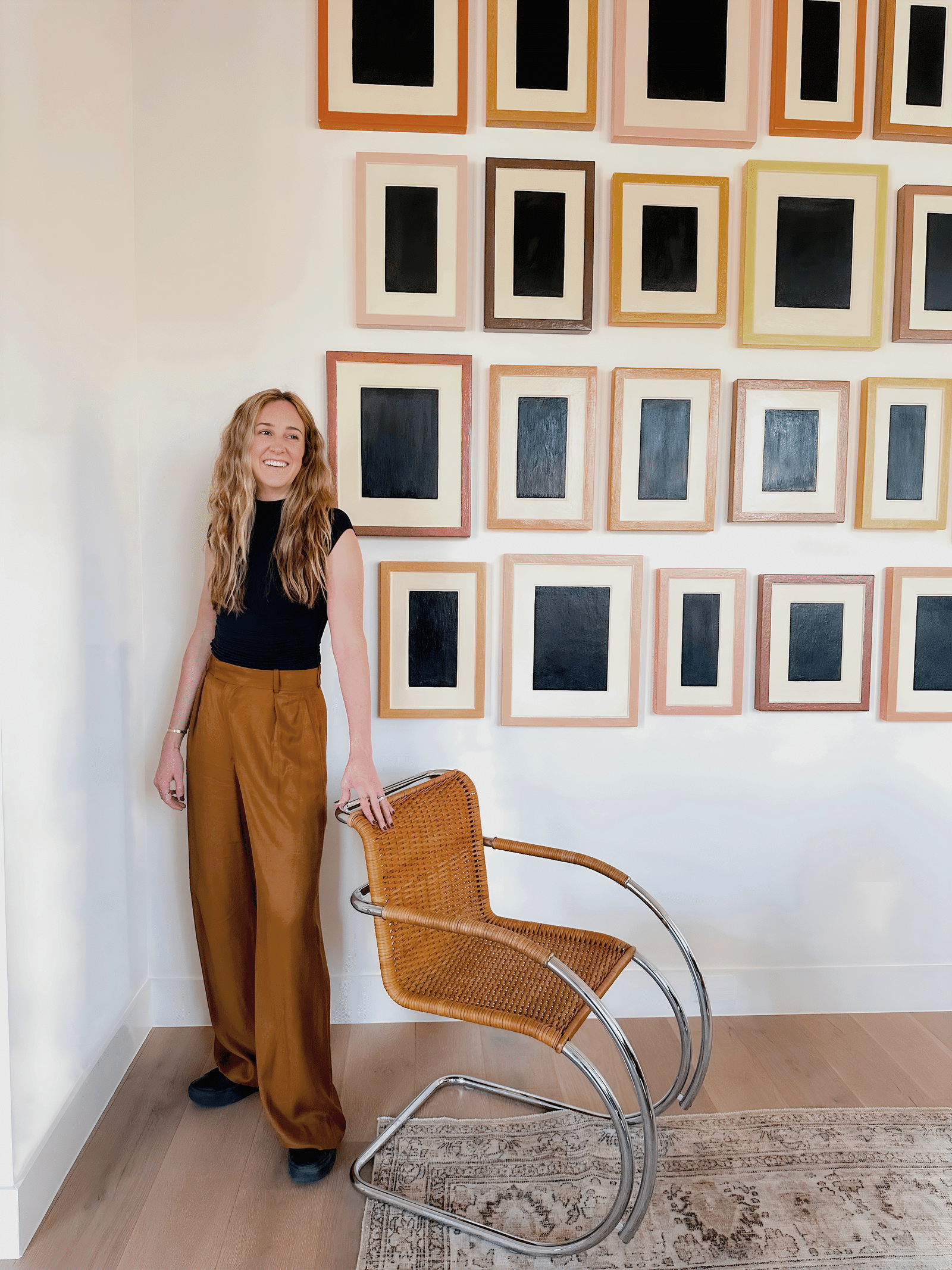 Cat leans on one of her MR20 armchairs with plaster artworks by Alan McCollum behind her.