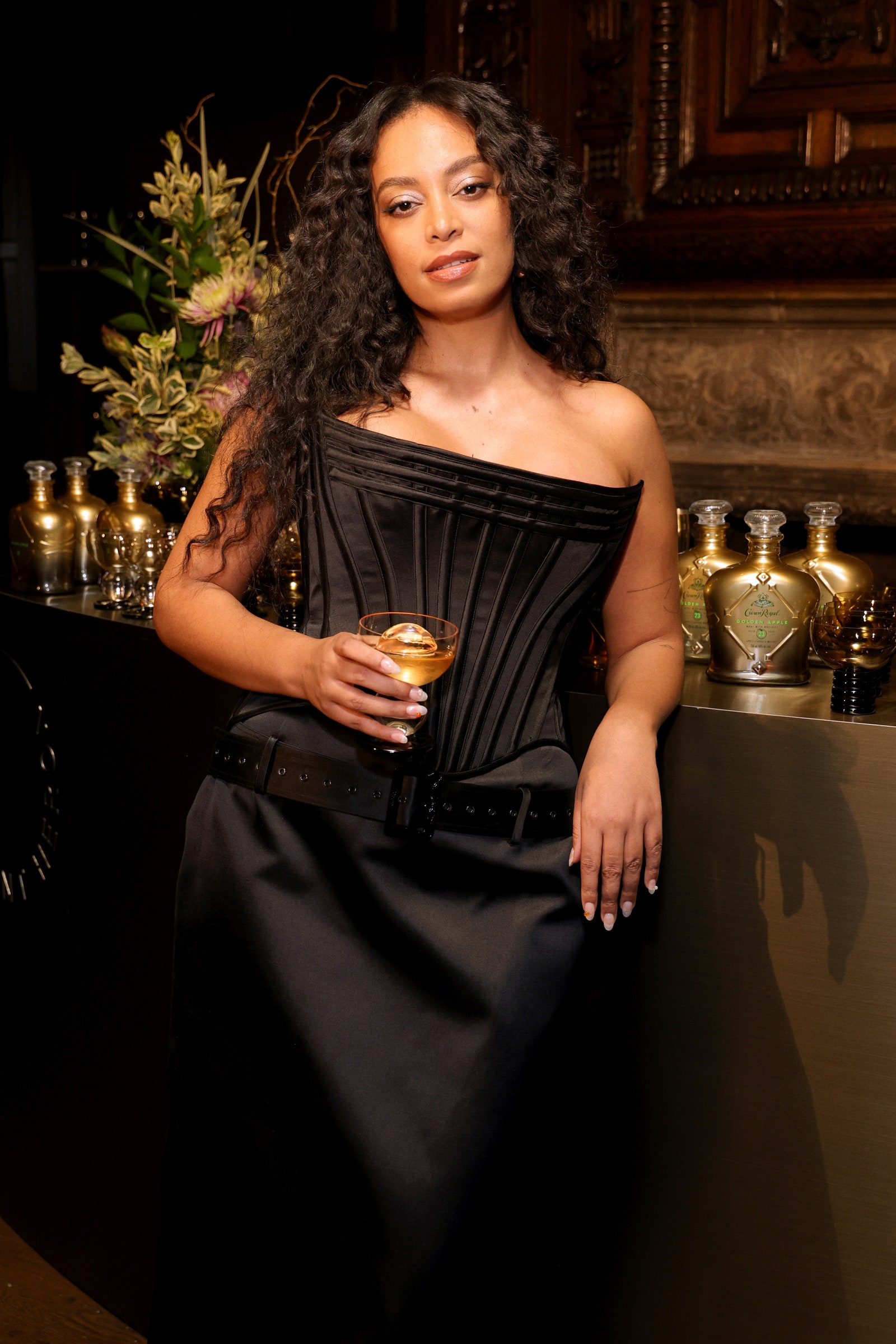 Knowles holds a cocktail in one of her new glasses.