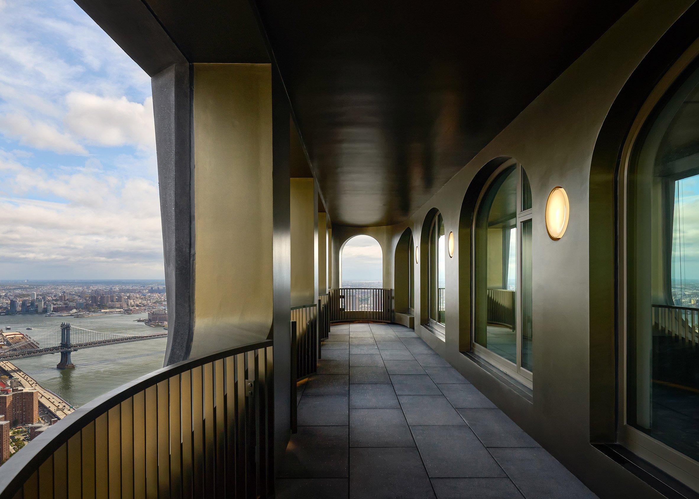 Loggia on top of Manhattan skyscraper with bridge in the background