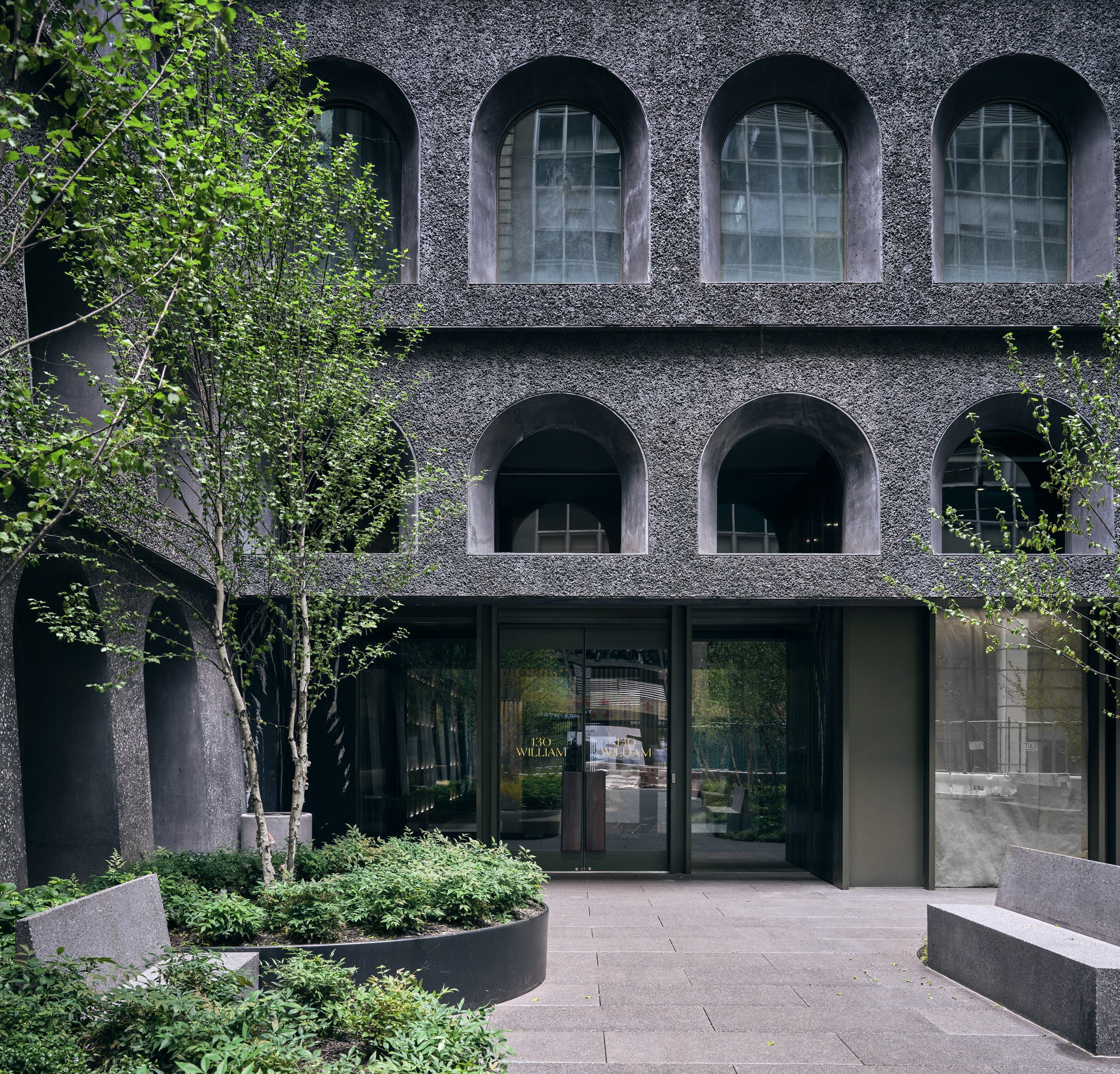 Textured facade and entryway to dark-clad manhattan 