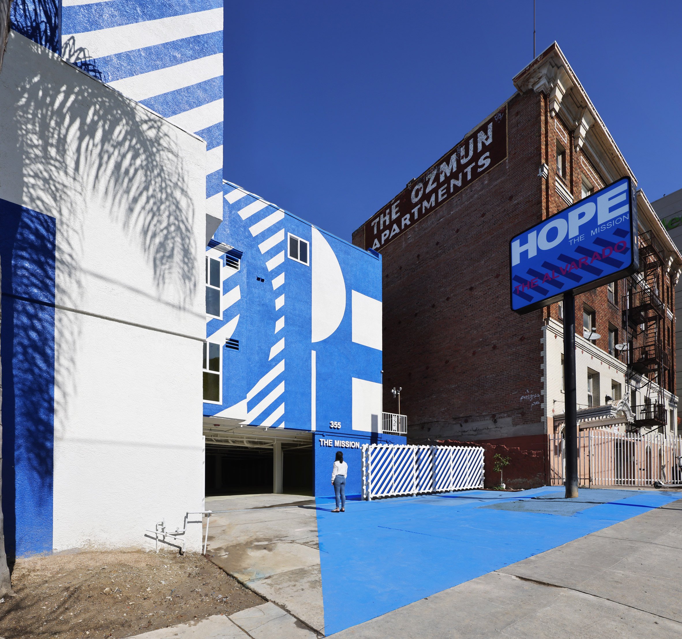 Exterior of the The Alvarado homeless shelter in LA with a graphic blue and white-painted facade