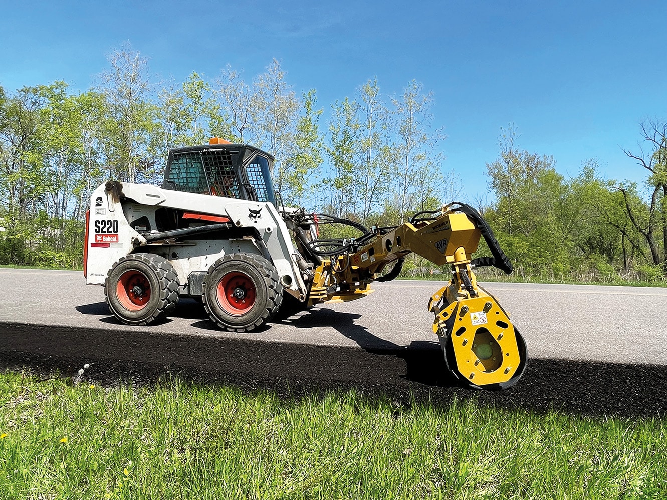 Road Widener’s Offset Vibratory Roller attachment allows operators to remain safely on flat ground while compacting sloping terrain.