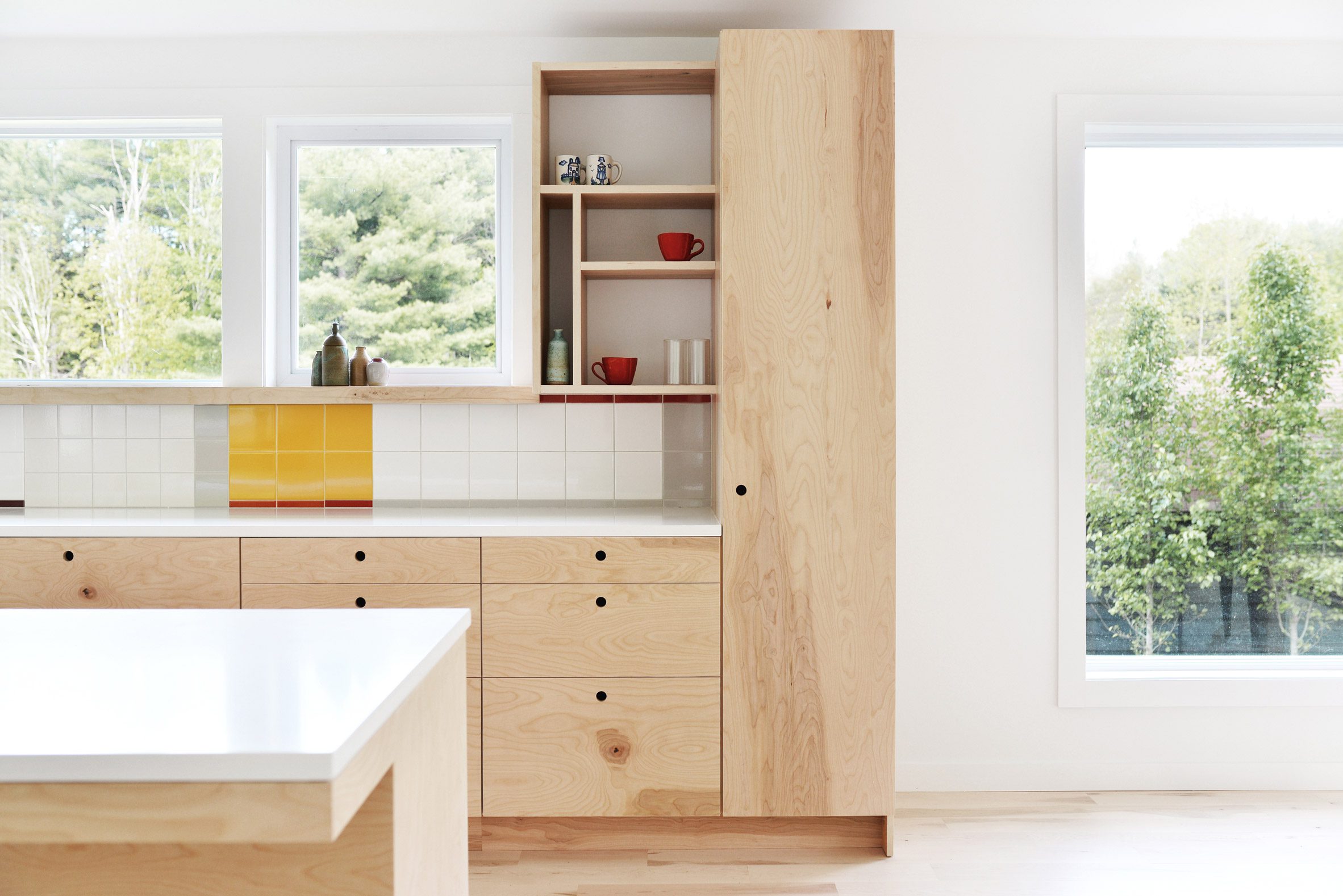 Open-plan kitchen and dining room with wood flooring and wood kitchen units