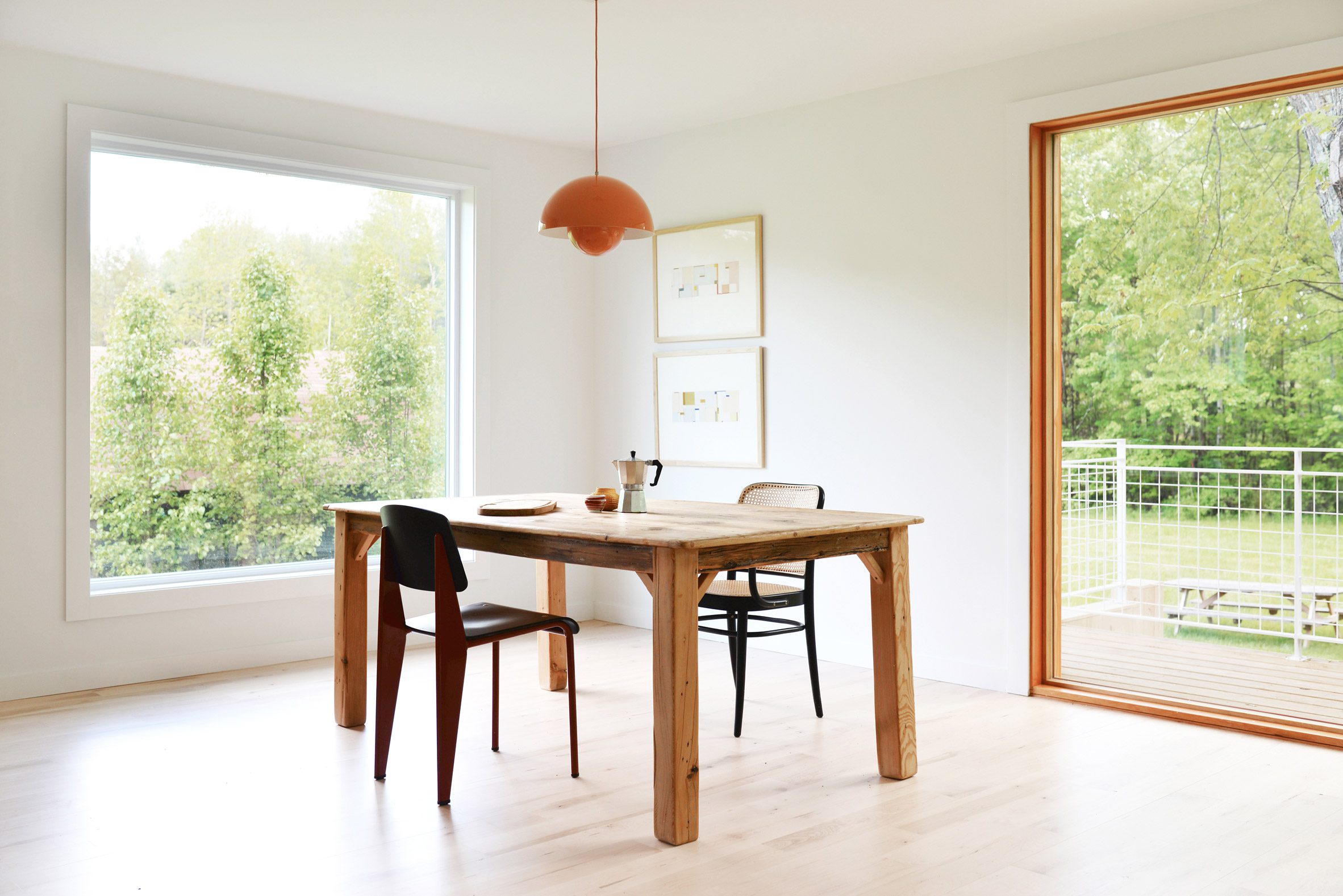 Dining room with white walls, wood flooring and a wood dining table