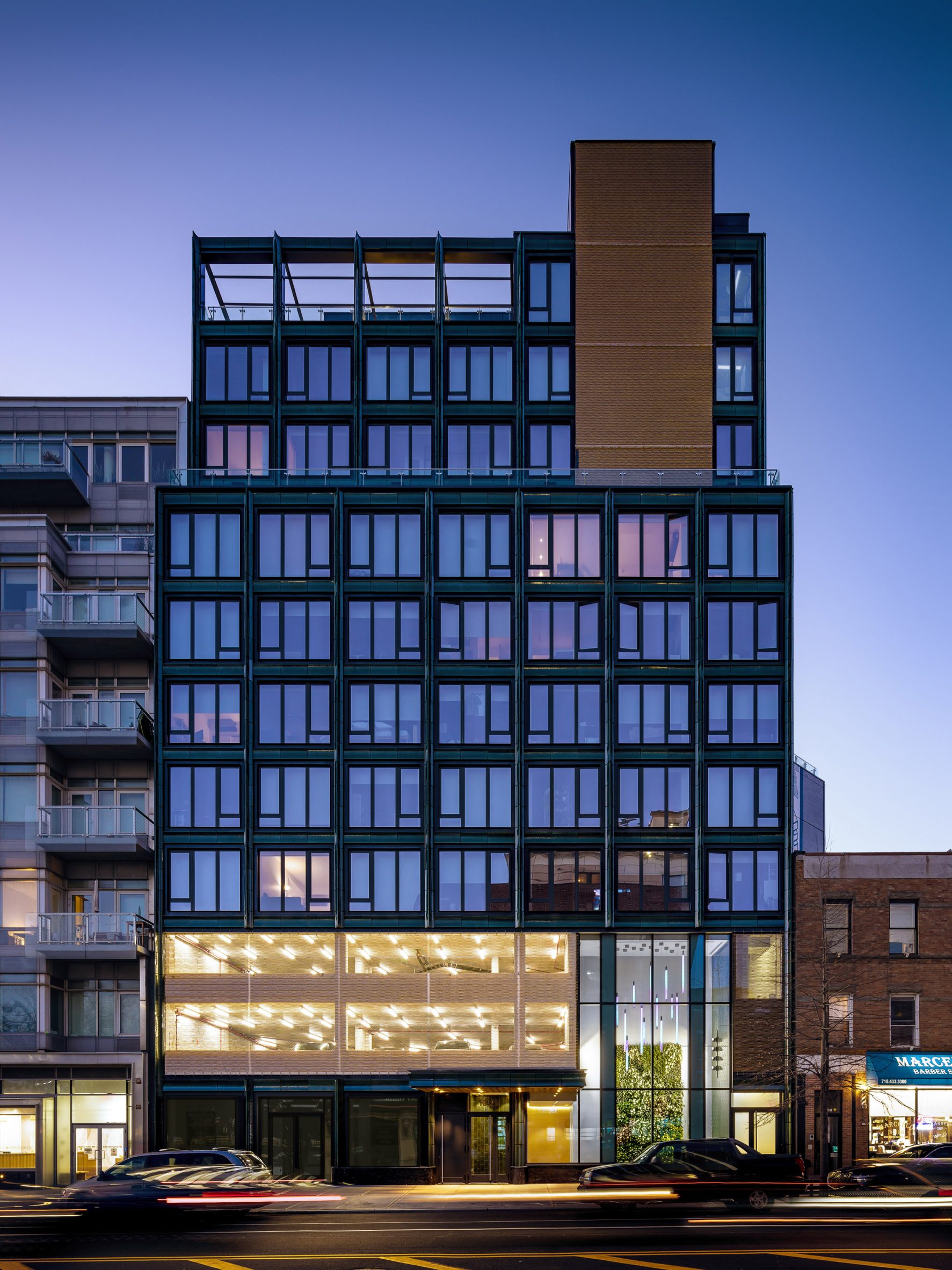 Green terracotta-clad building on Jackson Avenue at night