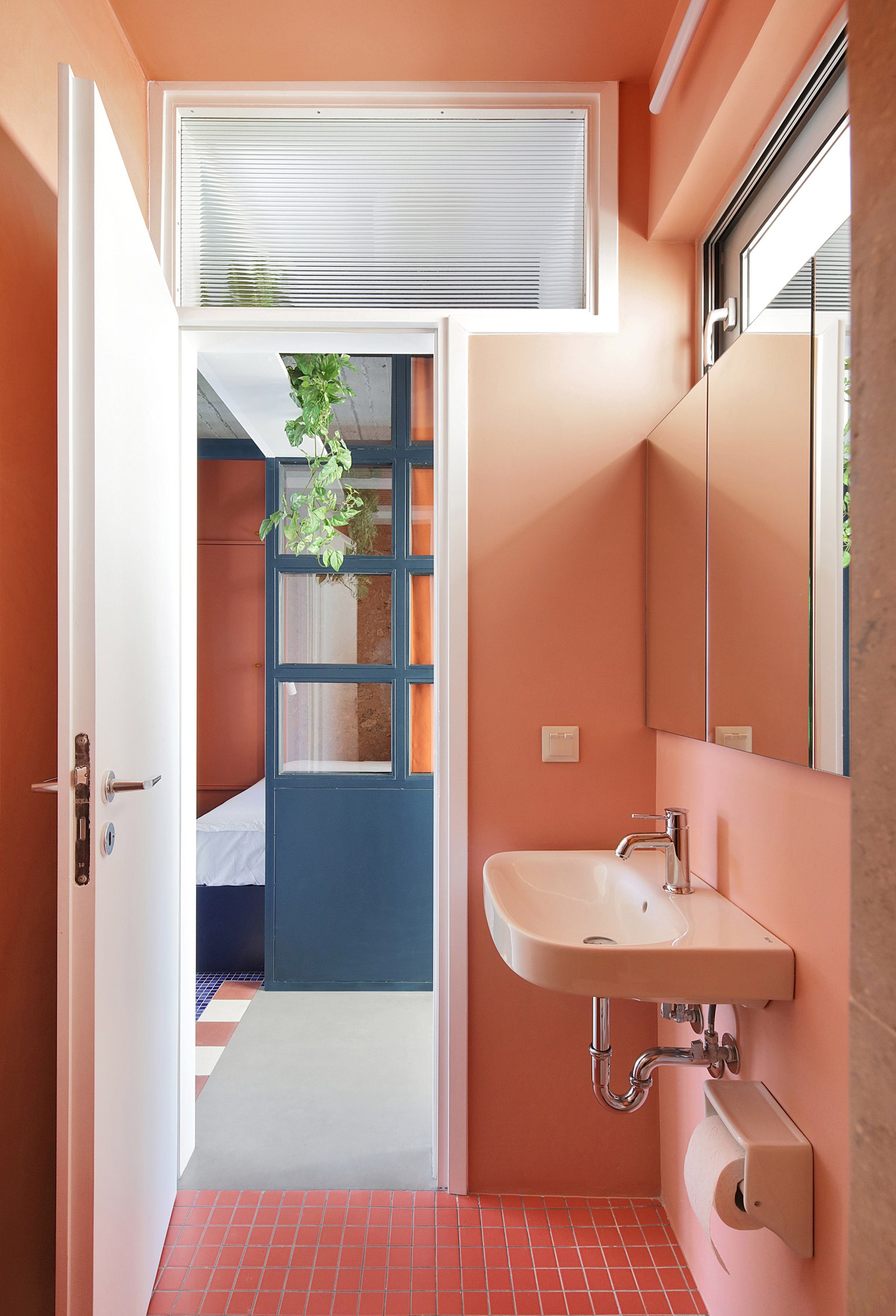 Porcelain floor tile and walls painted a peach hue in the bathroom.