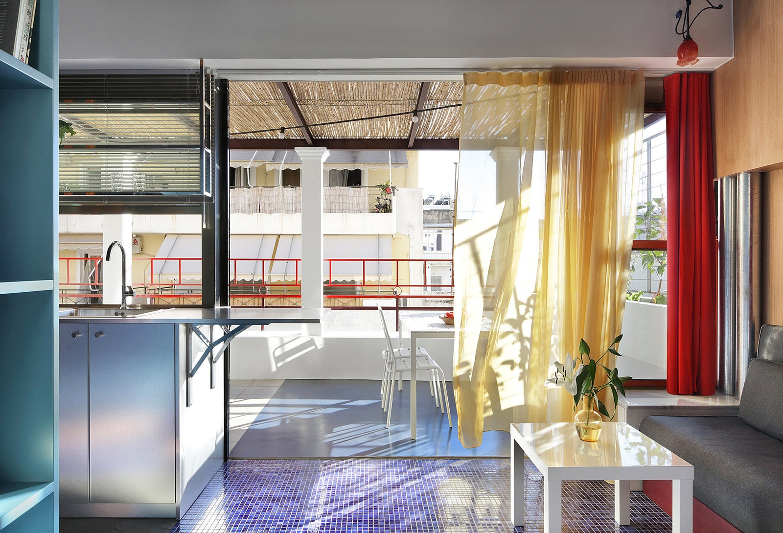 Diaphanous curtains blur the boundaries between the apartment and its terrace. Inside the kitchen countertop includes a...