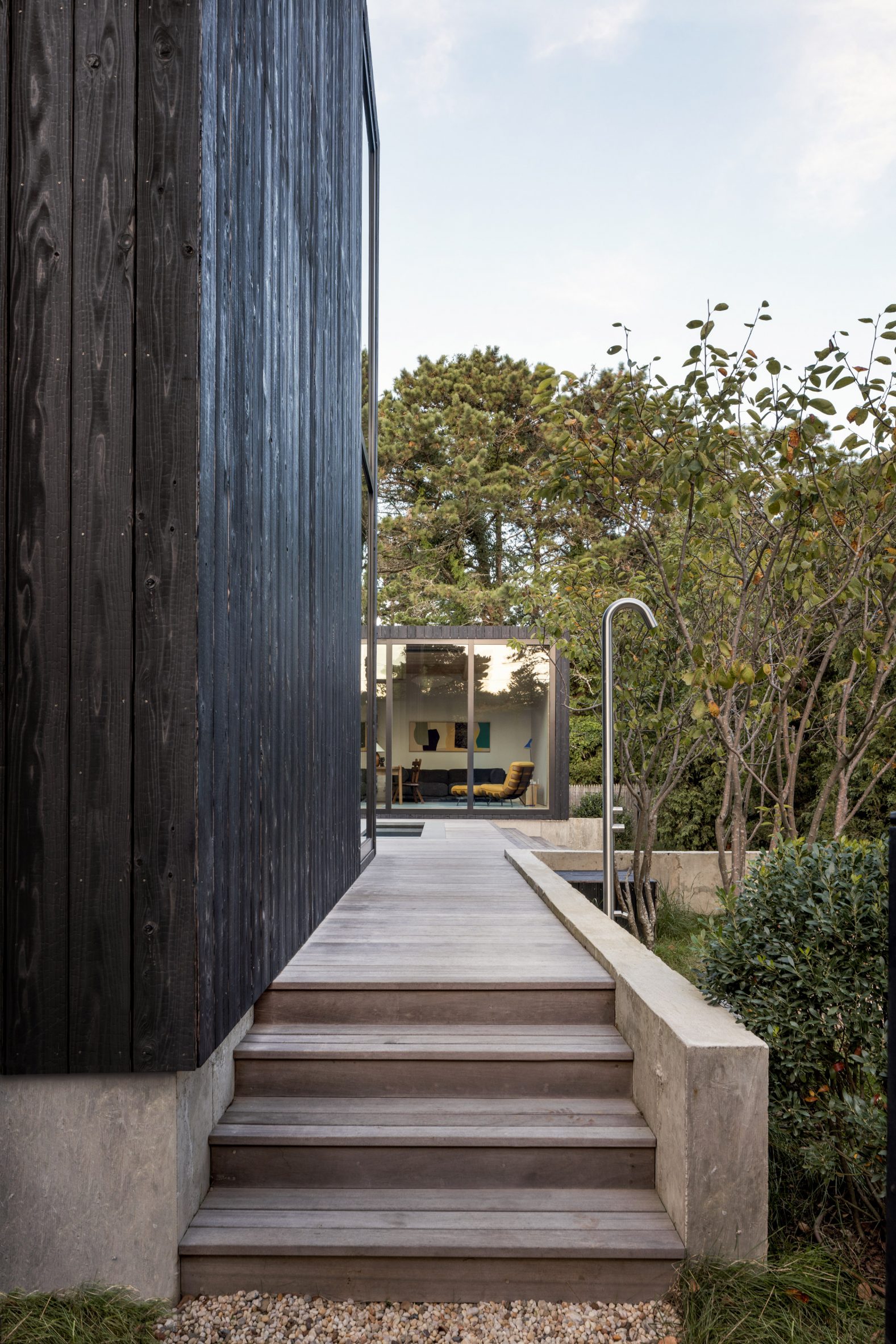 Steps and a wooden deck lead past an outdoor shower