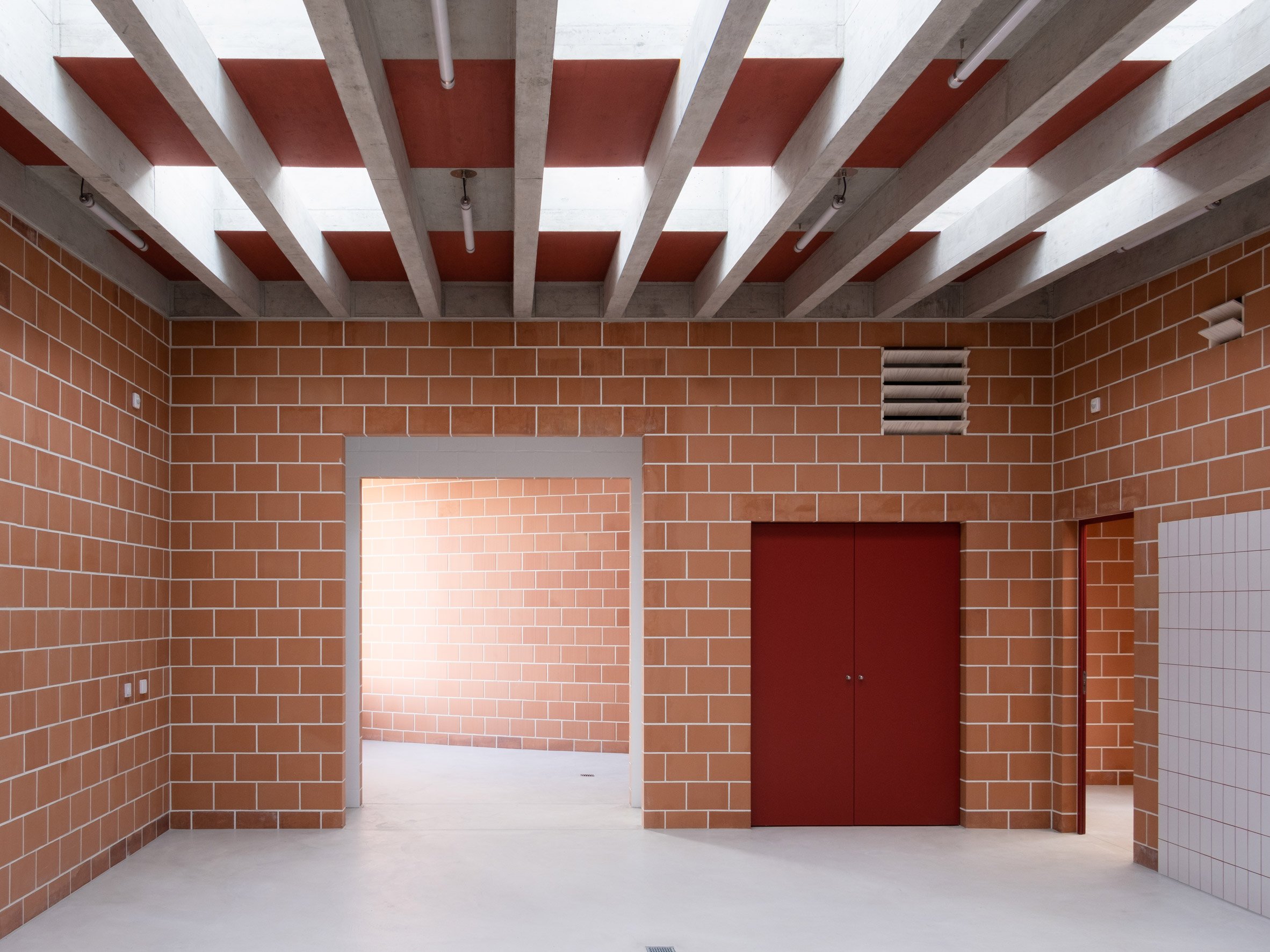 Terracotta-brick workshop interior with concrete roof beams