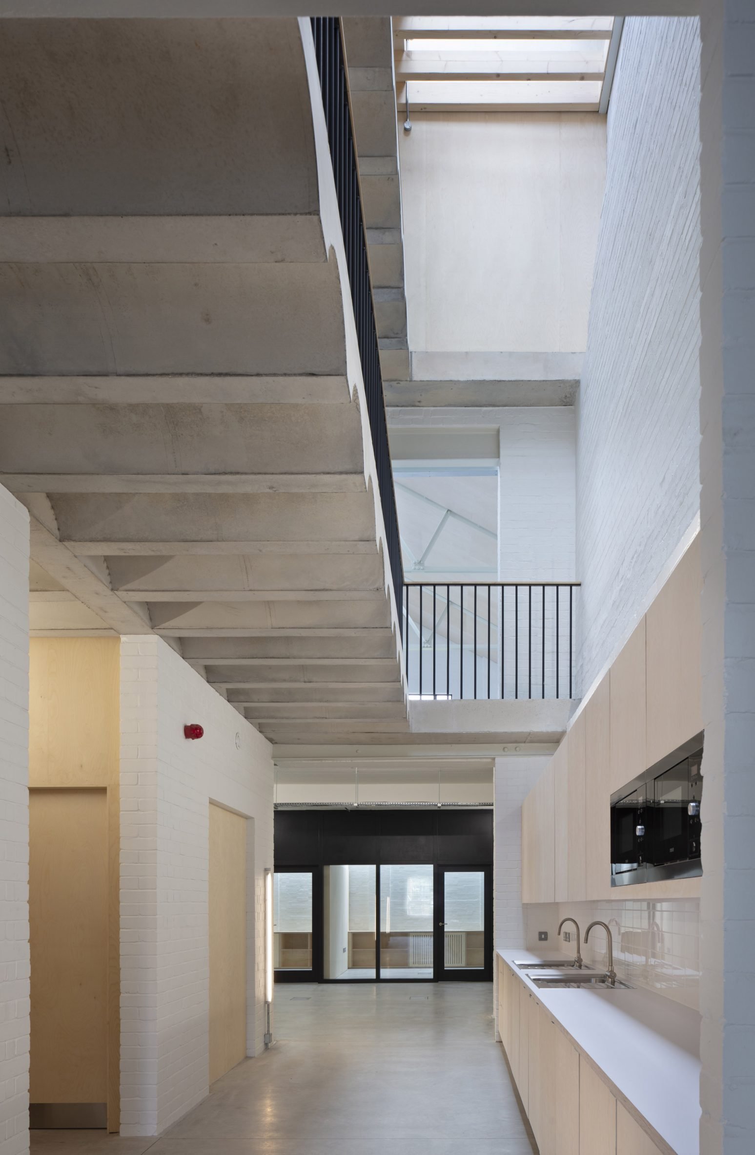 Walkway beneath concrete staircase by Henley Halebrown