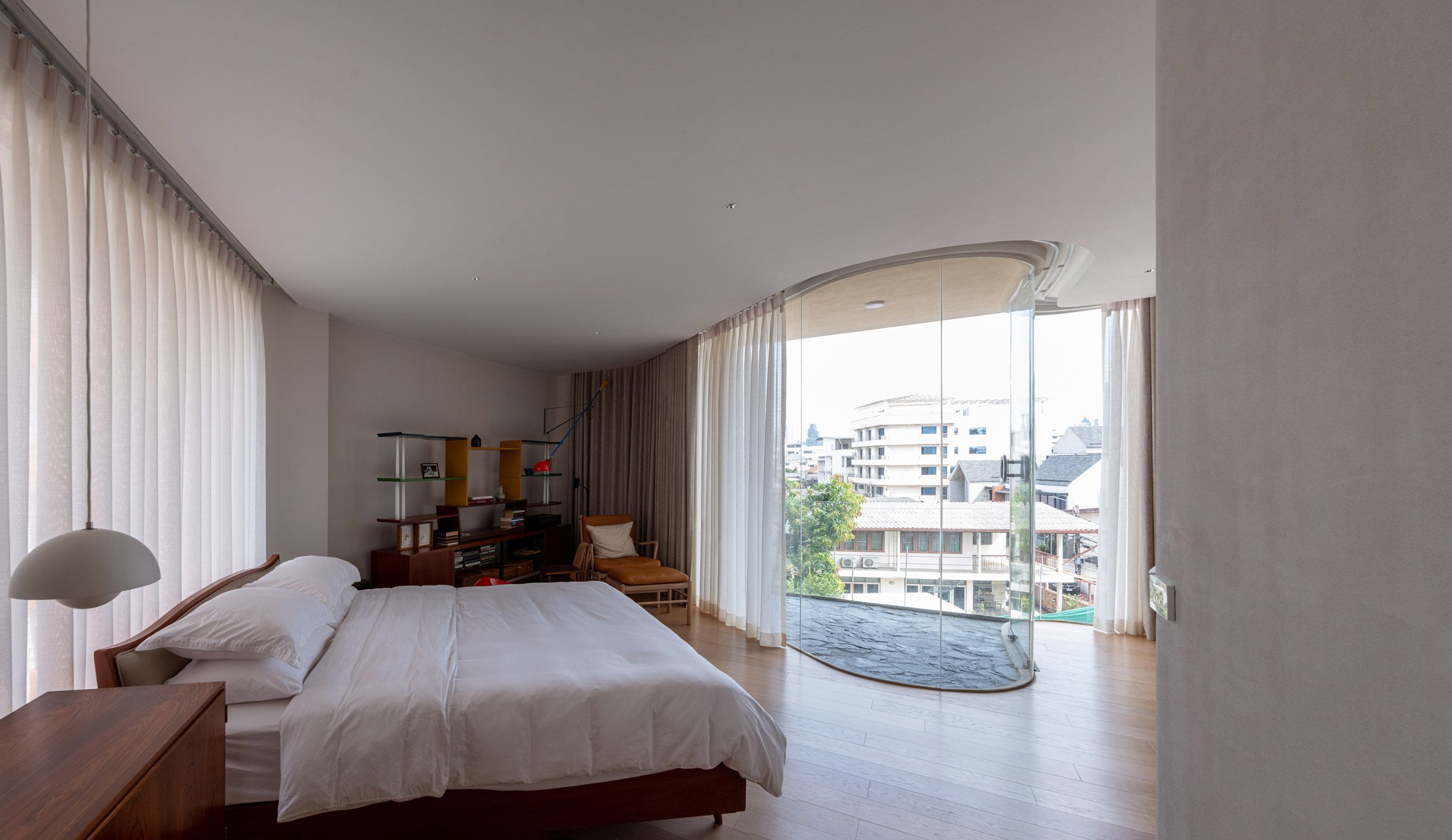 Photo of a bedroom in House R3 with a curved glass terrace 