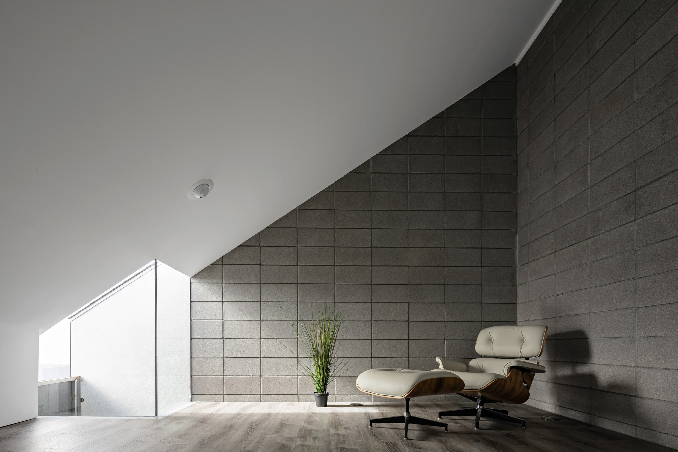 Room with a sloped roof and lounge chair