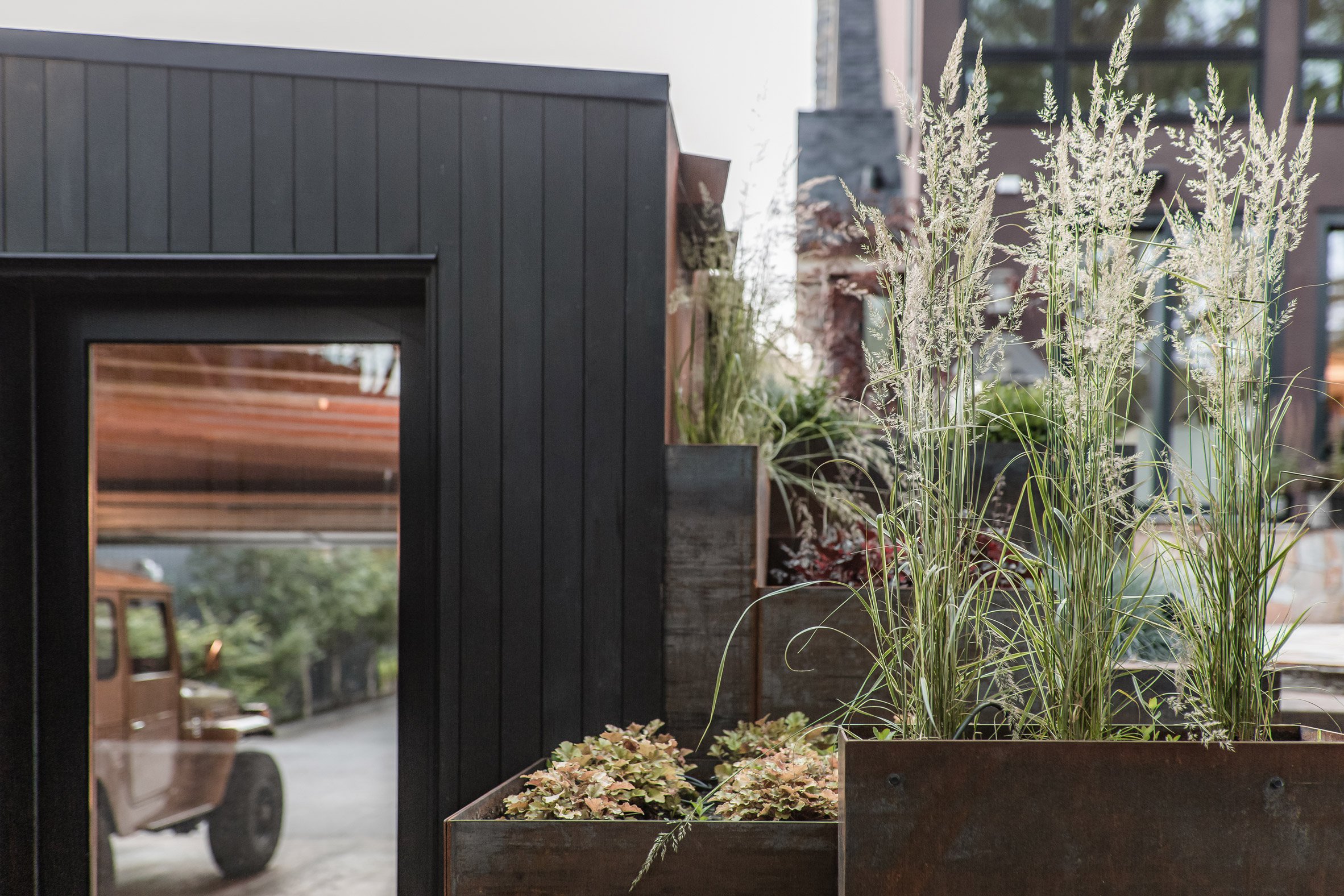 Blackened wood garage with rectilinear glazing