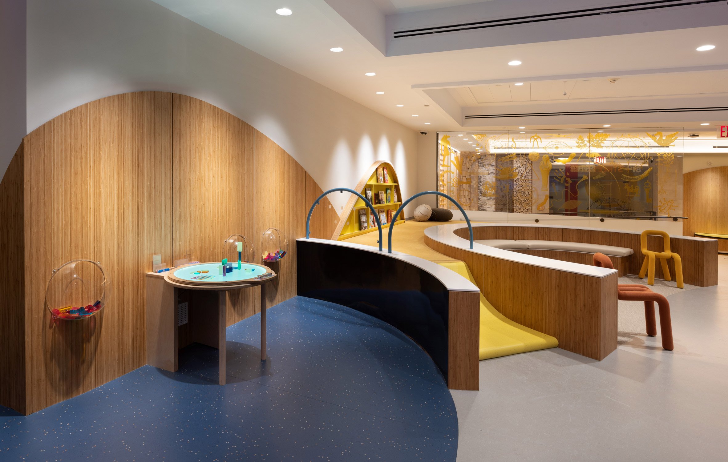 A children's playroom with wooden benches and a ramp