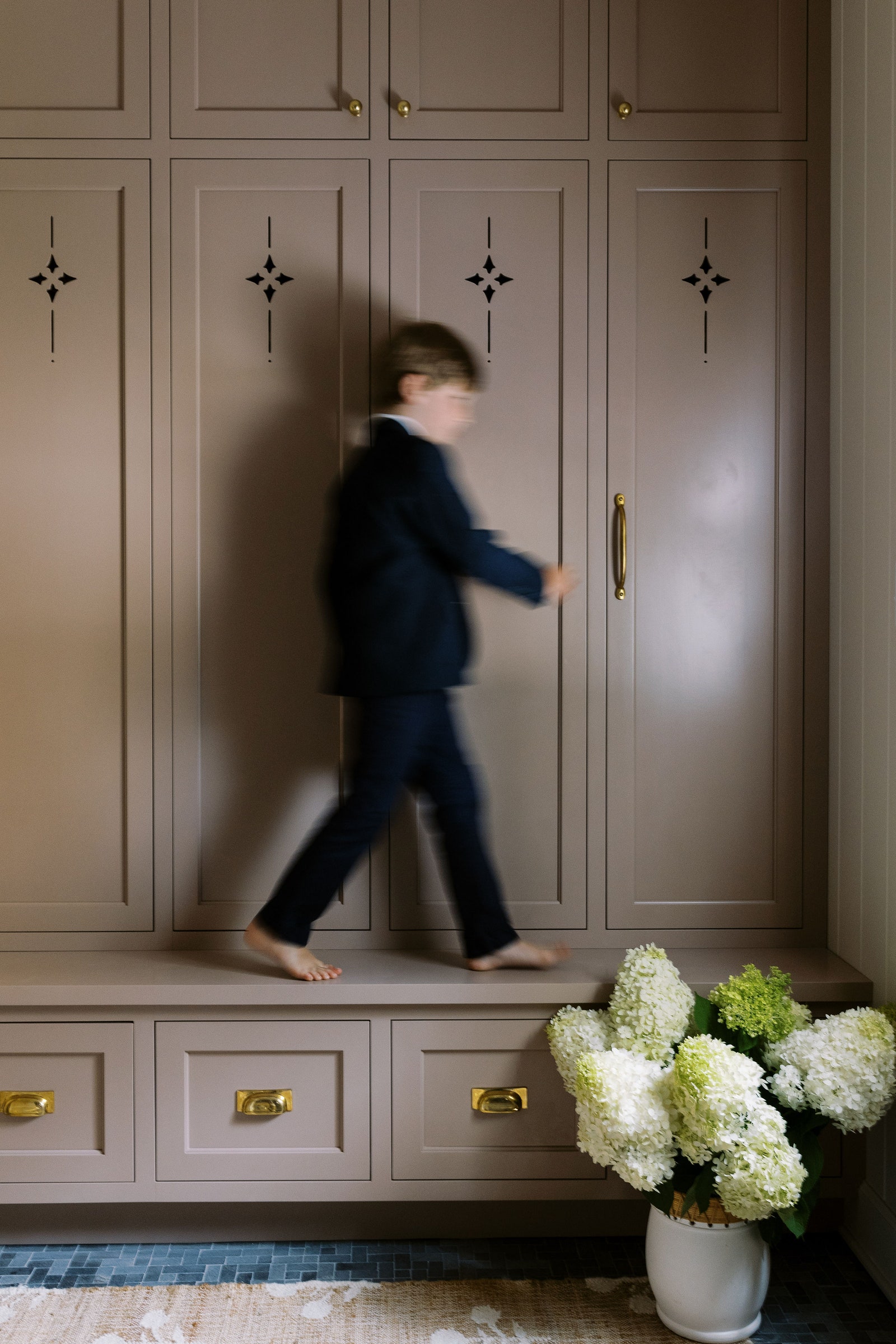 The creamy shade Whipped Mocha by Benjamin Moore adds an earthy touch to this mudroom designed by Weeth Home.