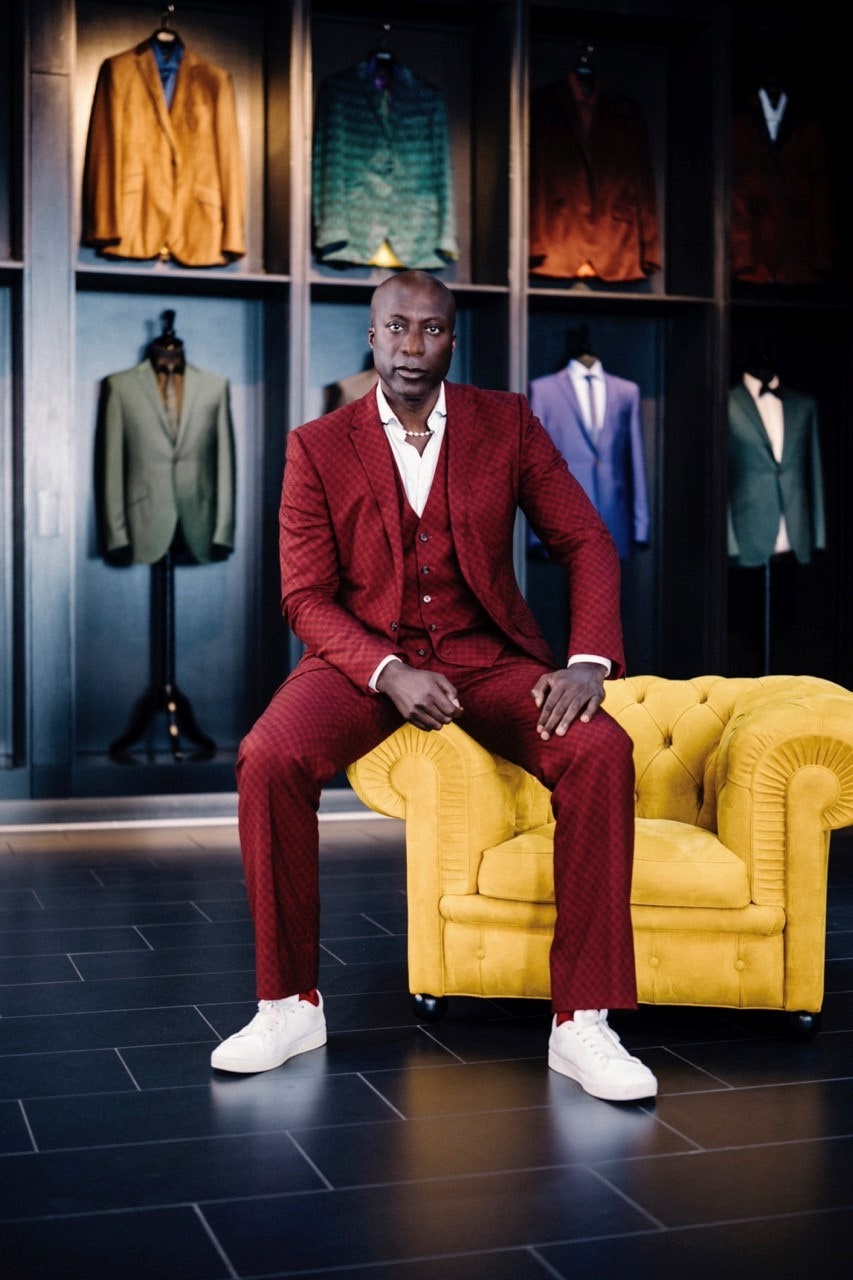 Ozwald Boateng perches on the Chester armchair upholstered in the collection's embossed leather.