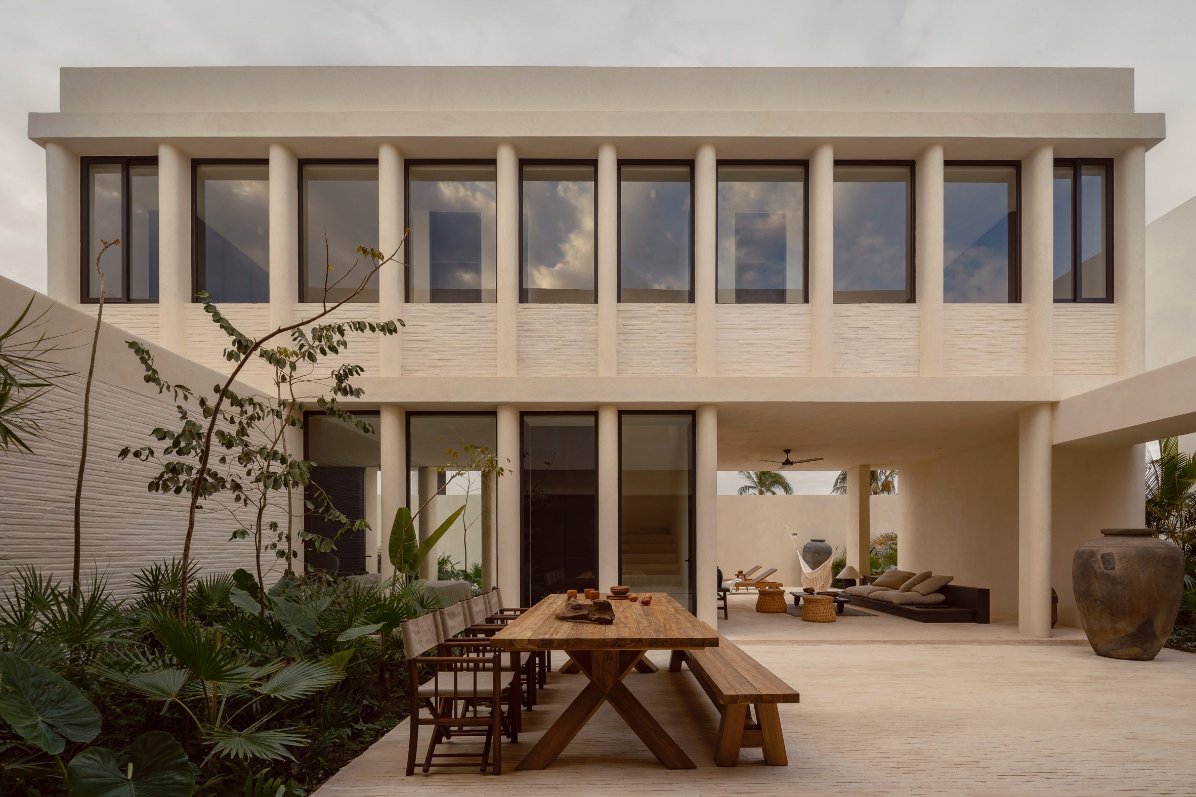 Courtyard with large wooden dining table and tropical planting