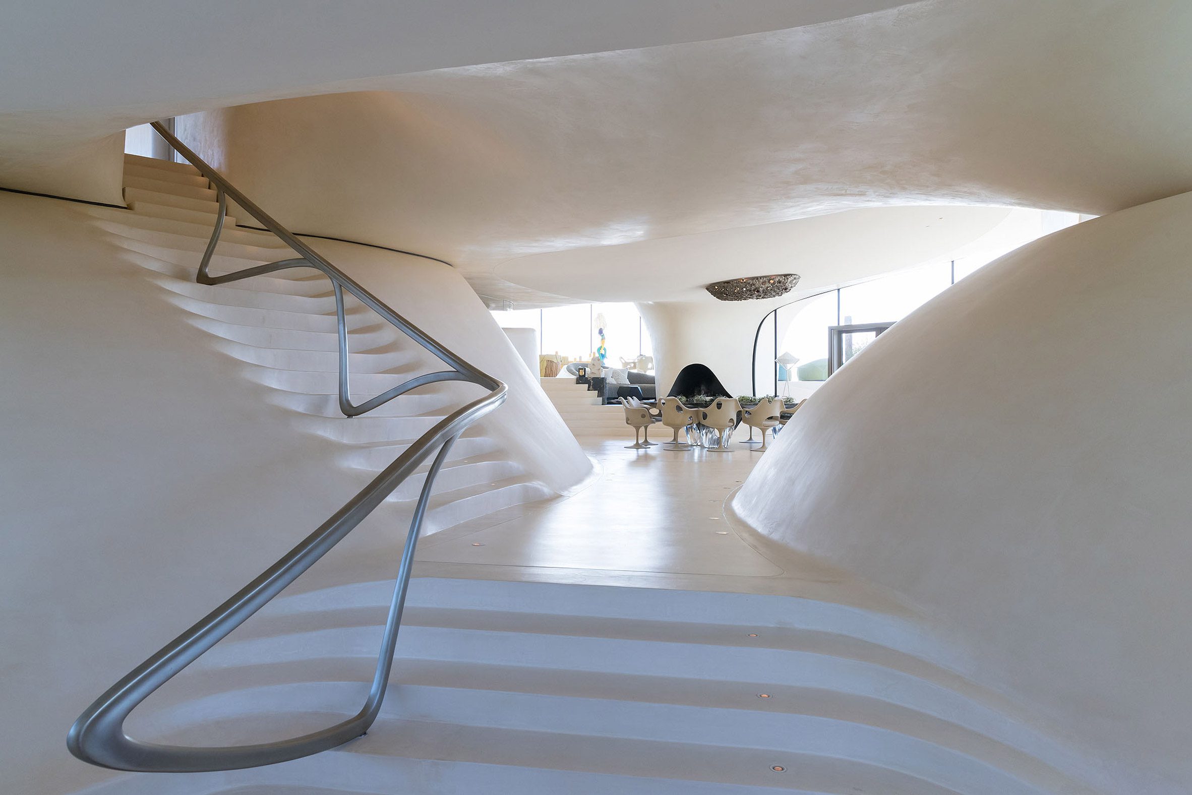 White cement interior in modern house with sculptural metal railing