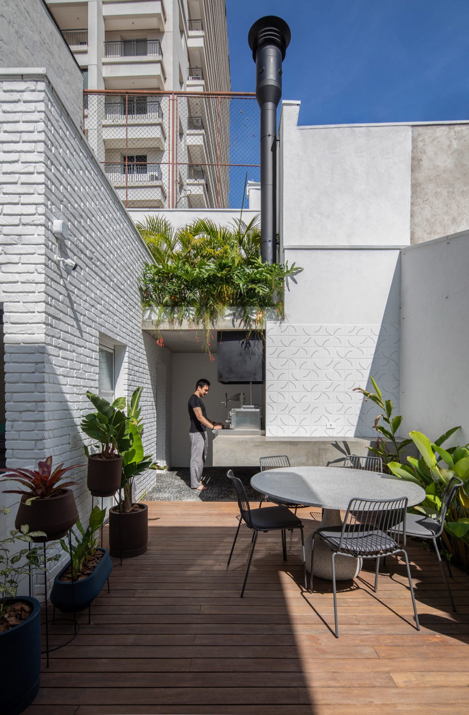 Outdoor wood decking at a white brick house in Sao Paulo