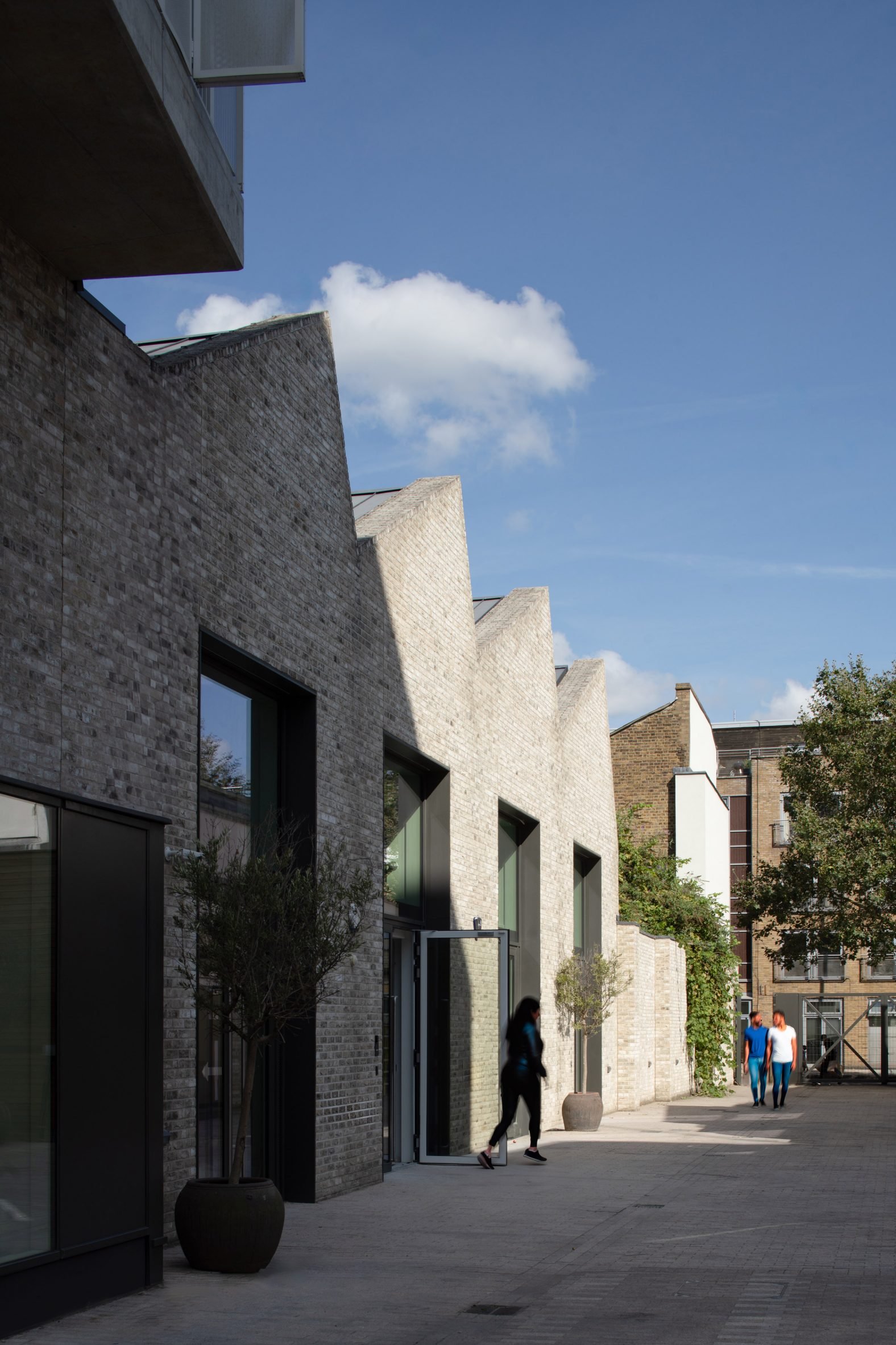 Brick housing and arts building with a saw tooth roof by Coffey Architects