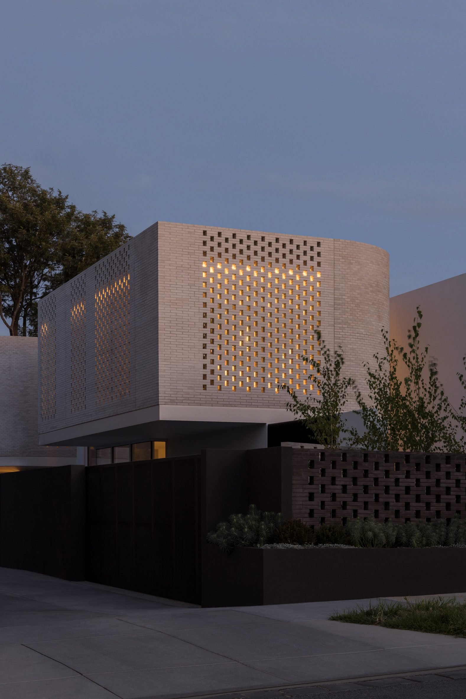 Light shining out from perforated brickwork facade
