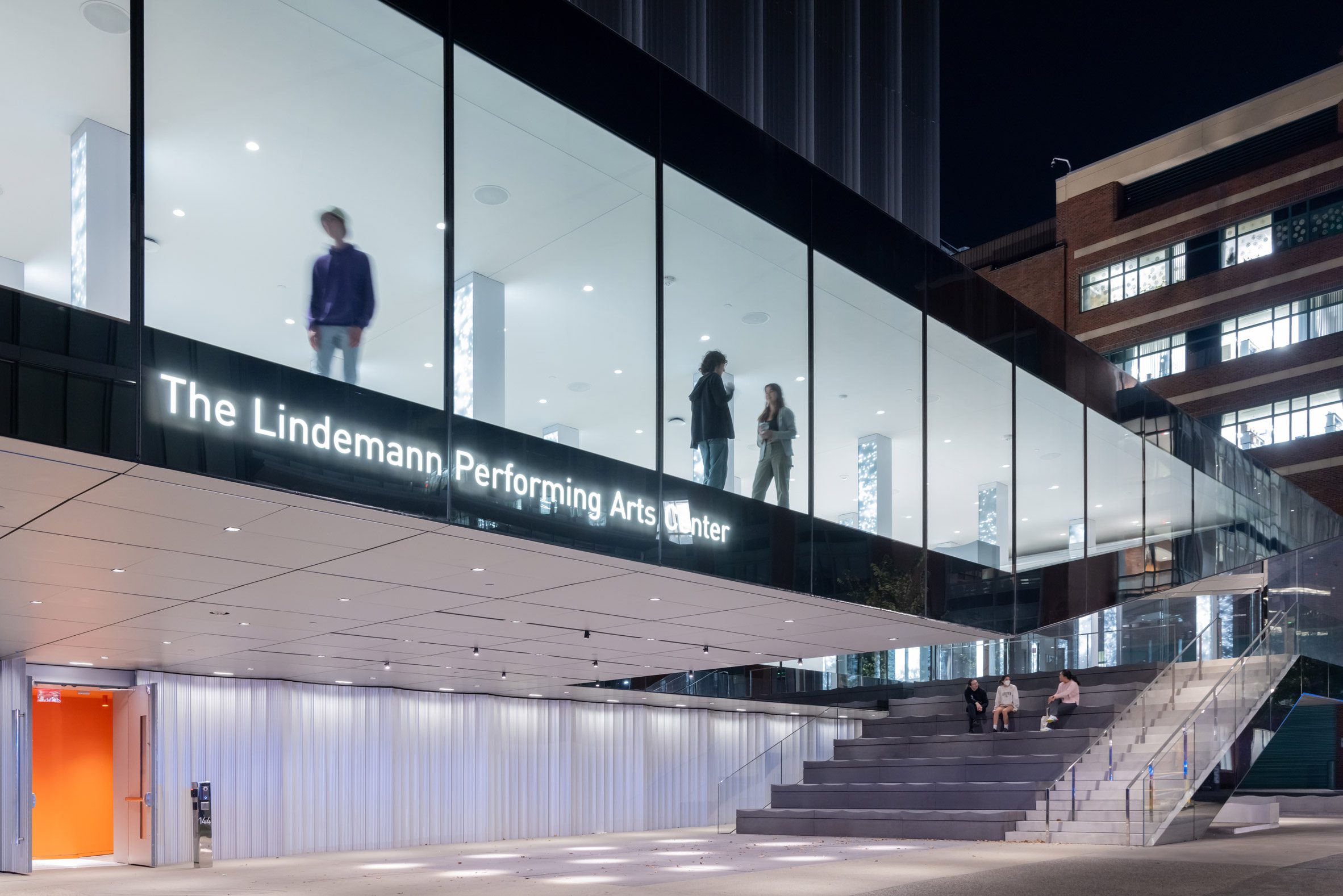 People standing in the window of a cantilevered lobby