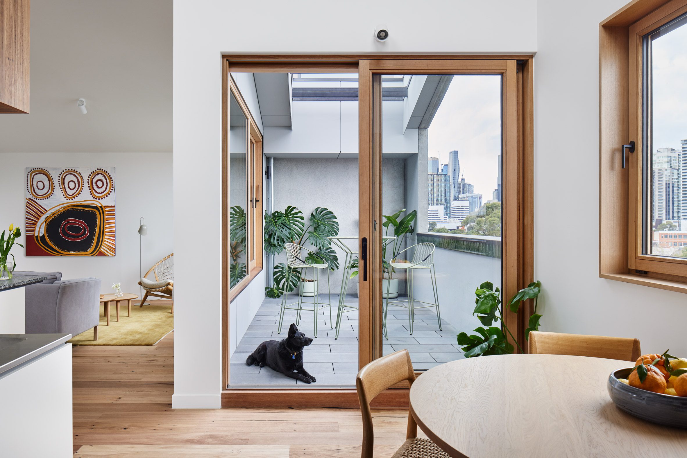 Interior space with wood flooring and glazed doors leading to a balcony