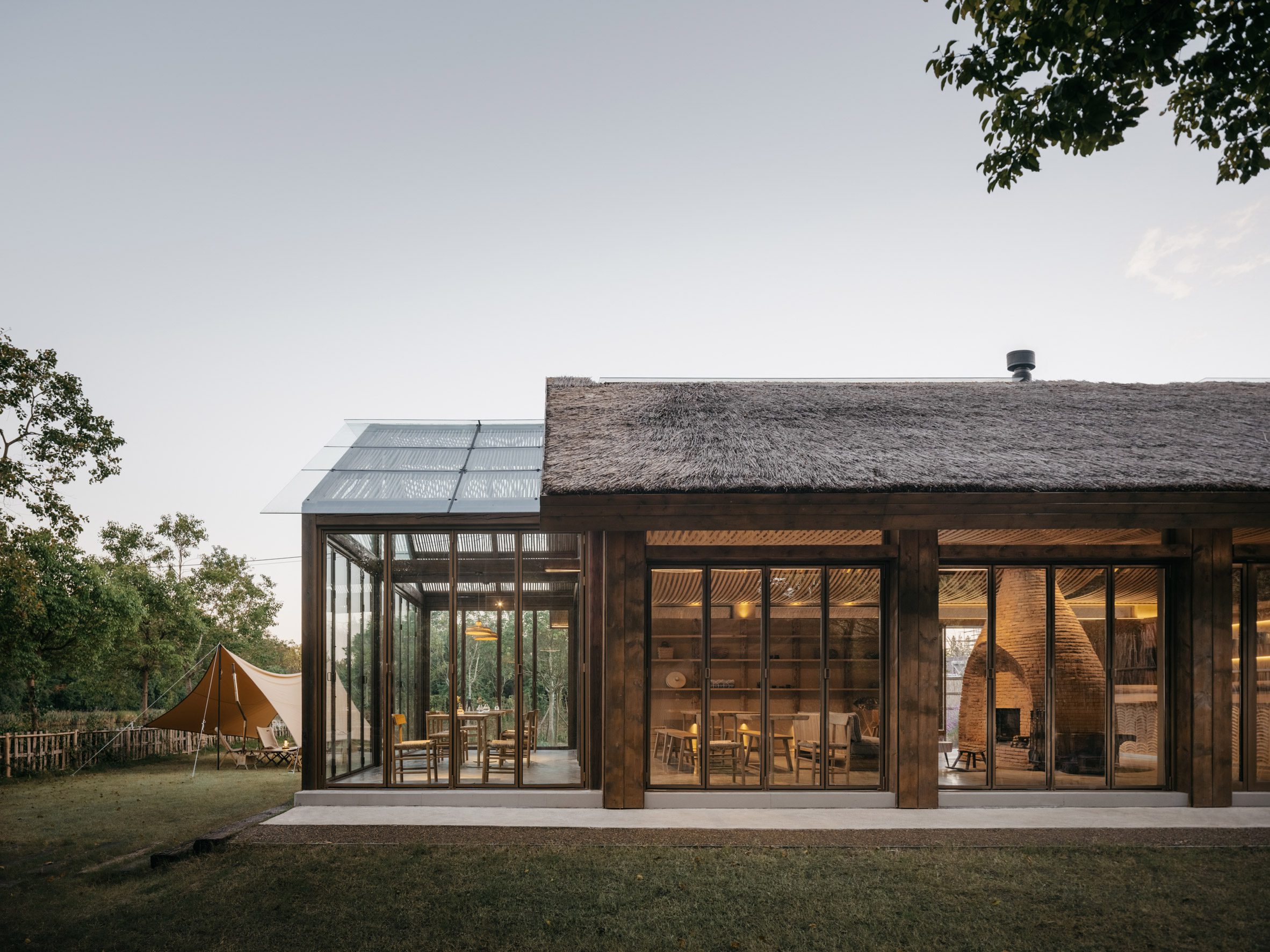 Thatched building with a glass extension
