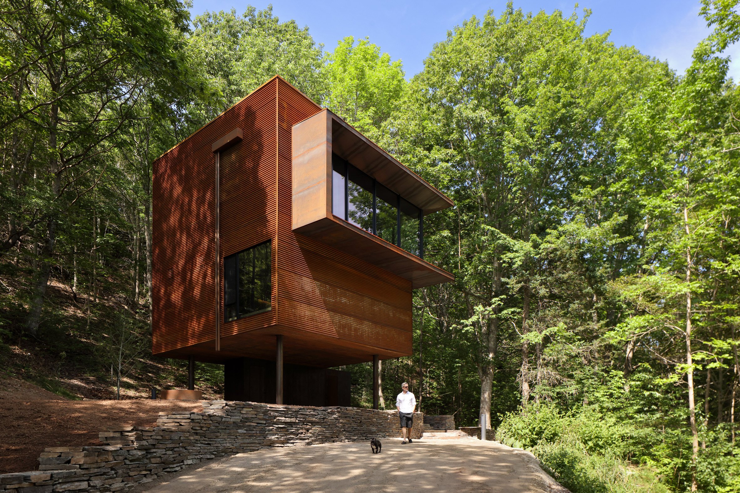 Corten steel cube cabin on stilts