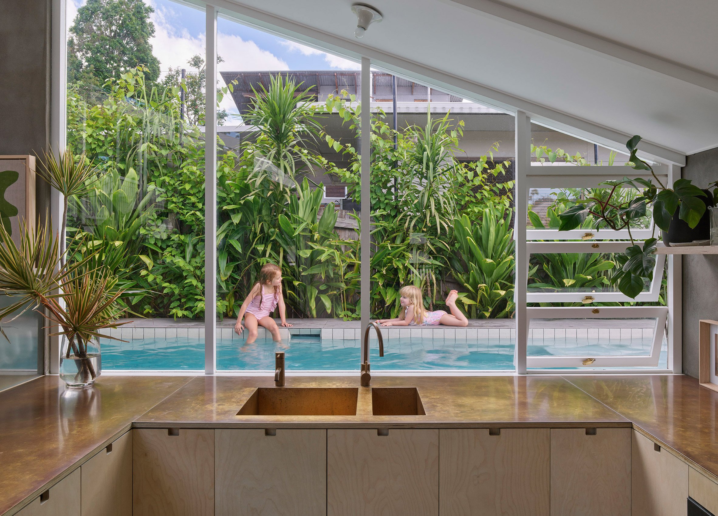 Kitchen overlooking an outdoor home swimming pool