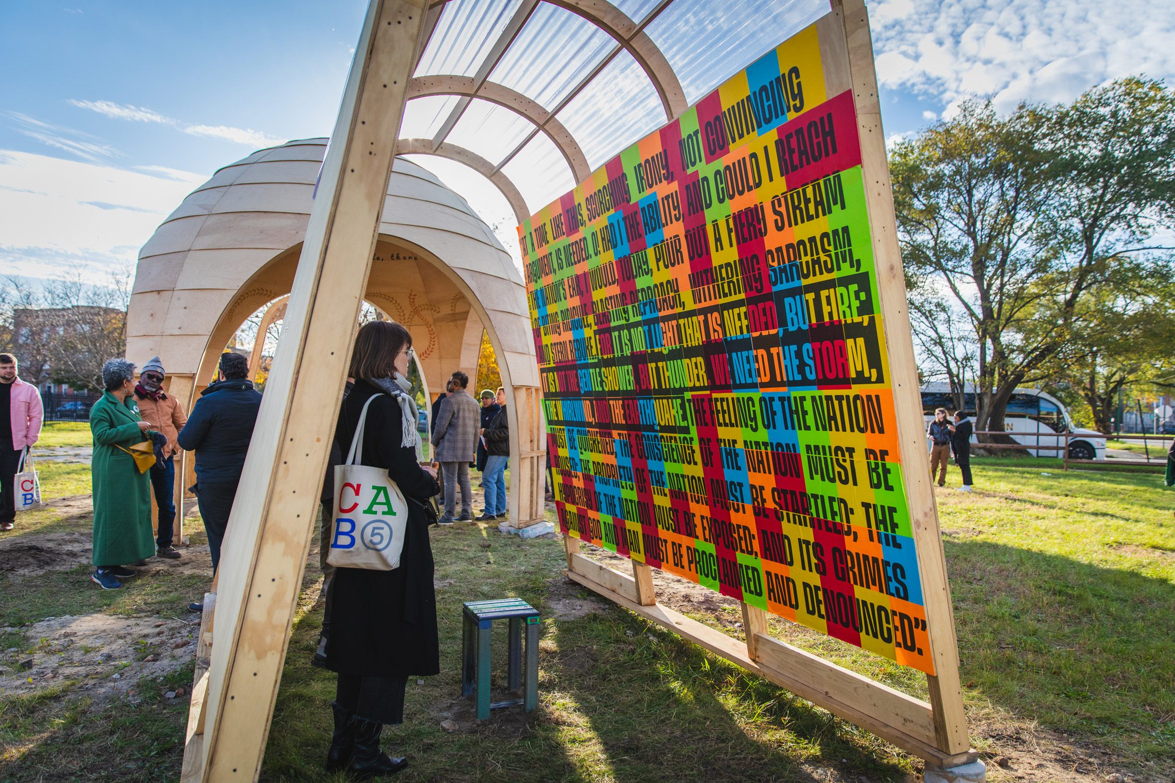 Colourful graphics being read by a woman with a tote bag