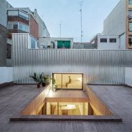 Metal-clad home with a tiled patio in Barcelona by CRÜ