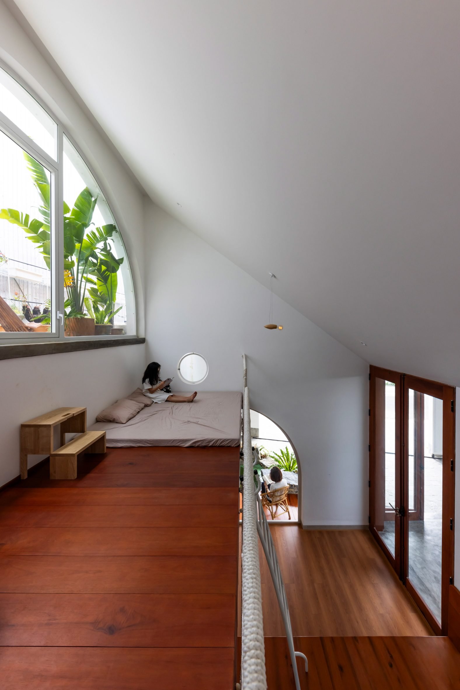 Mezzanine children's bedroom with dark wood flooring and white walls