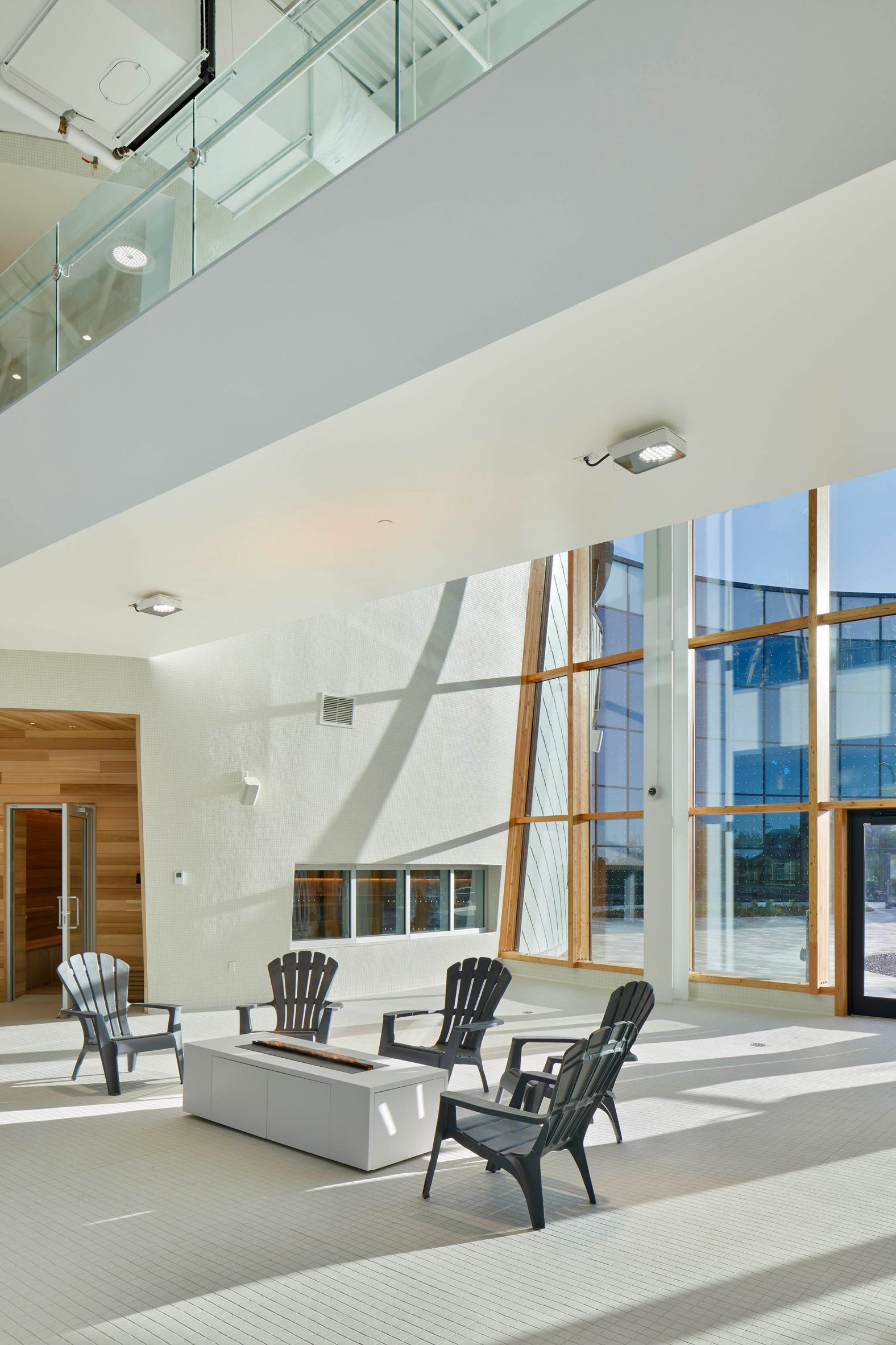 A lobby with textured wall and floor to ceiling windows