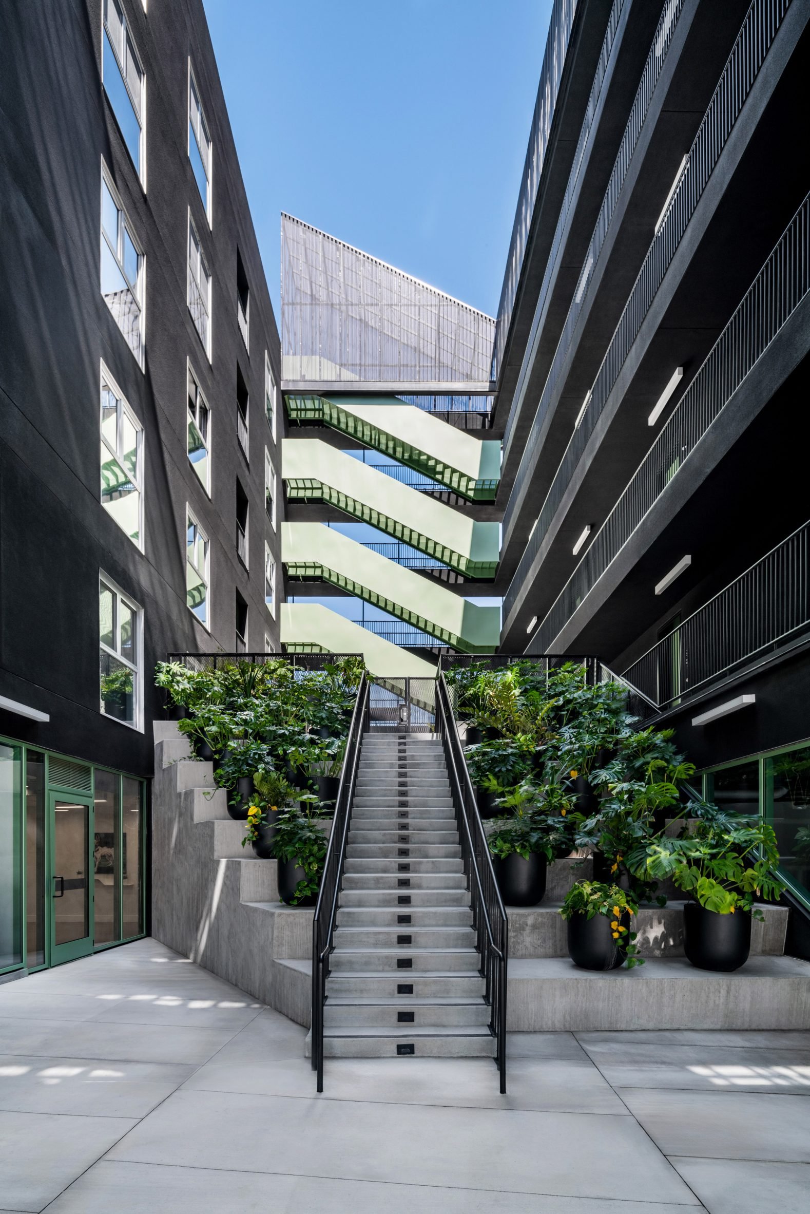 Green staircase at the end of open-air courtyard