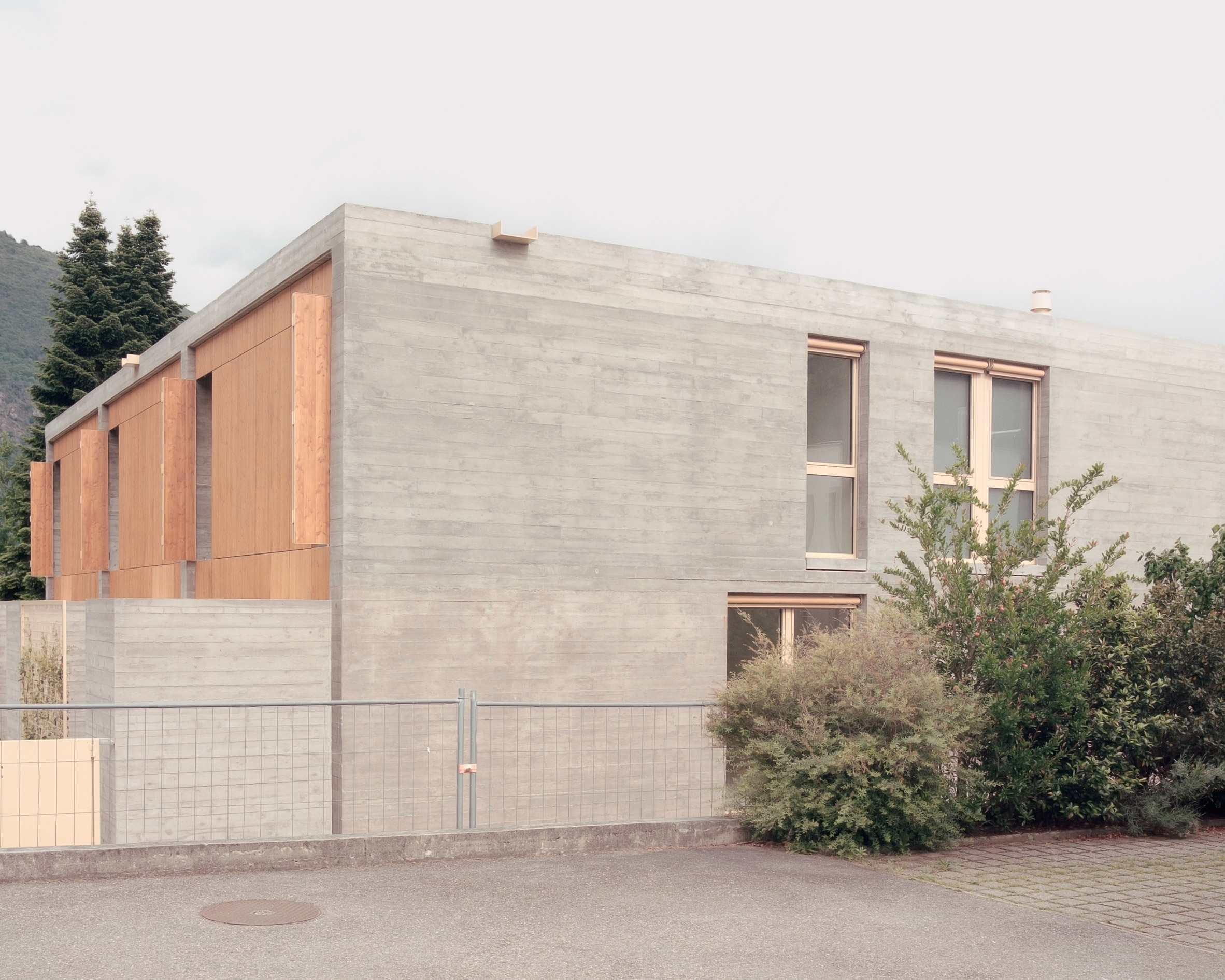 Reinforced concrete wall and timber cladding of concrete terrace houses in Switzerland by Atelier Rampazzi