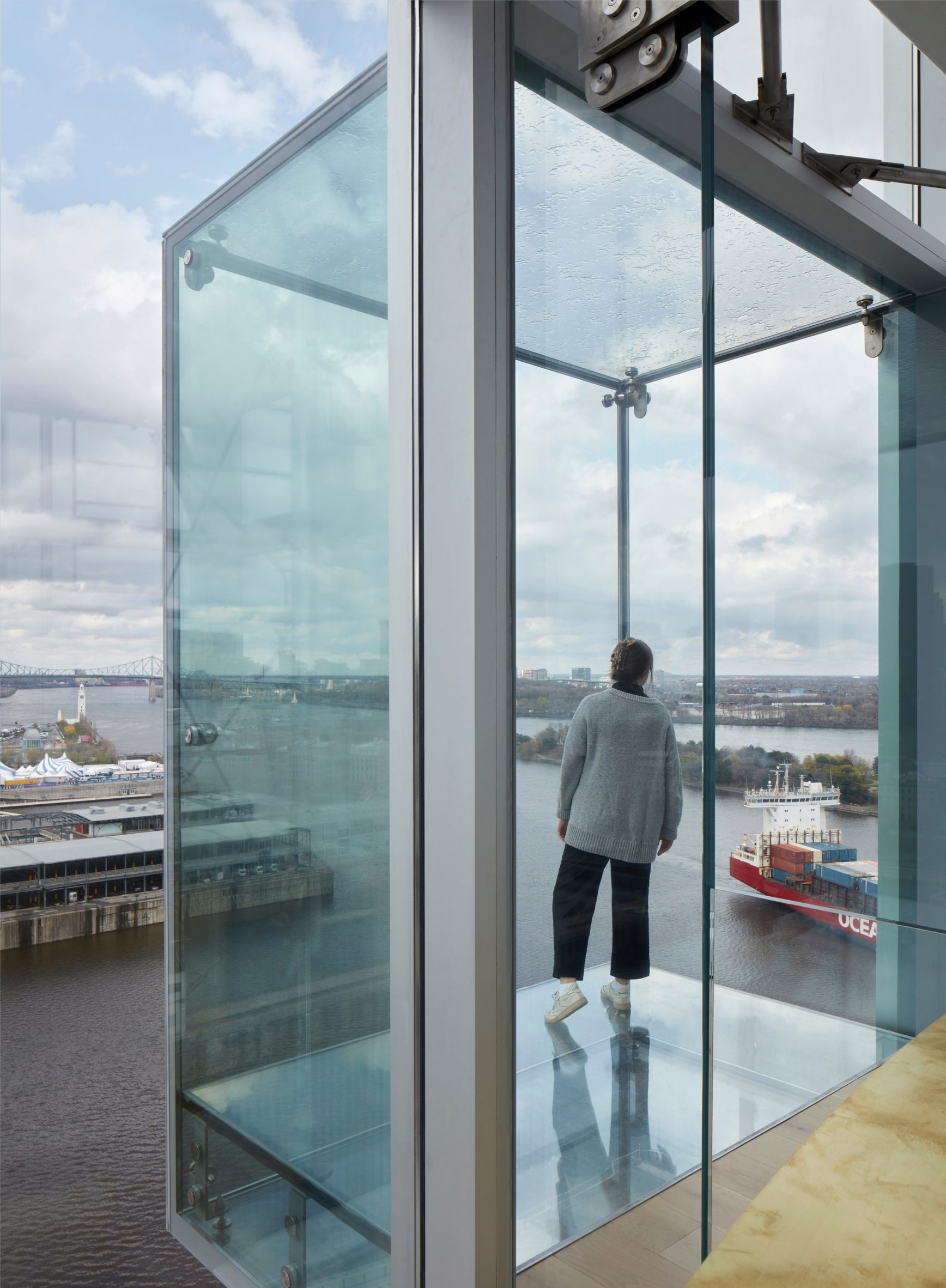 Woman in glass belvedere in tower of montreal port